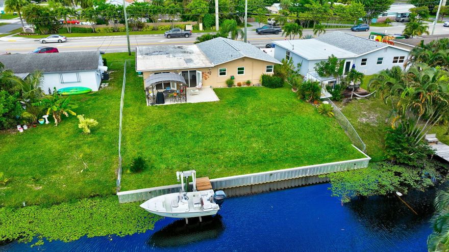 Quintessential Waterfront Living - No HOA! This charming 3-bedroom, 2-bath single-family waterfront home offers a private boat dock with access to Lake Osborne and Lake Ida, providing miles of boating, fishing, and water fun. No HOA, close to everything, and just 3 minutes to I-95, with restaurants and shopping nearby. The home features a split floor plan with a living room, dining room, and family room--perfect for comfortable daily living and entertaining. The backyard is the true highlight, showcasing a gazebo, grassy yard, canal frontage, and private dock. A new retractable screen connects the family/dining room to the outdoors, creating the ultimate Florida lifestyle experience.Recent upgrades include:Roof (2020) Hurricane-impact windows and doors, including garage door