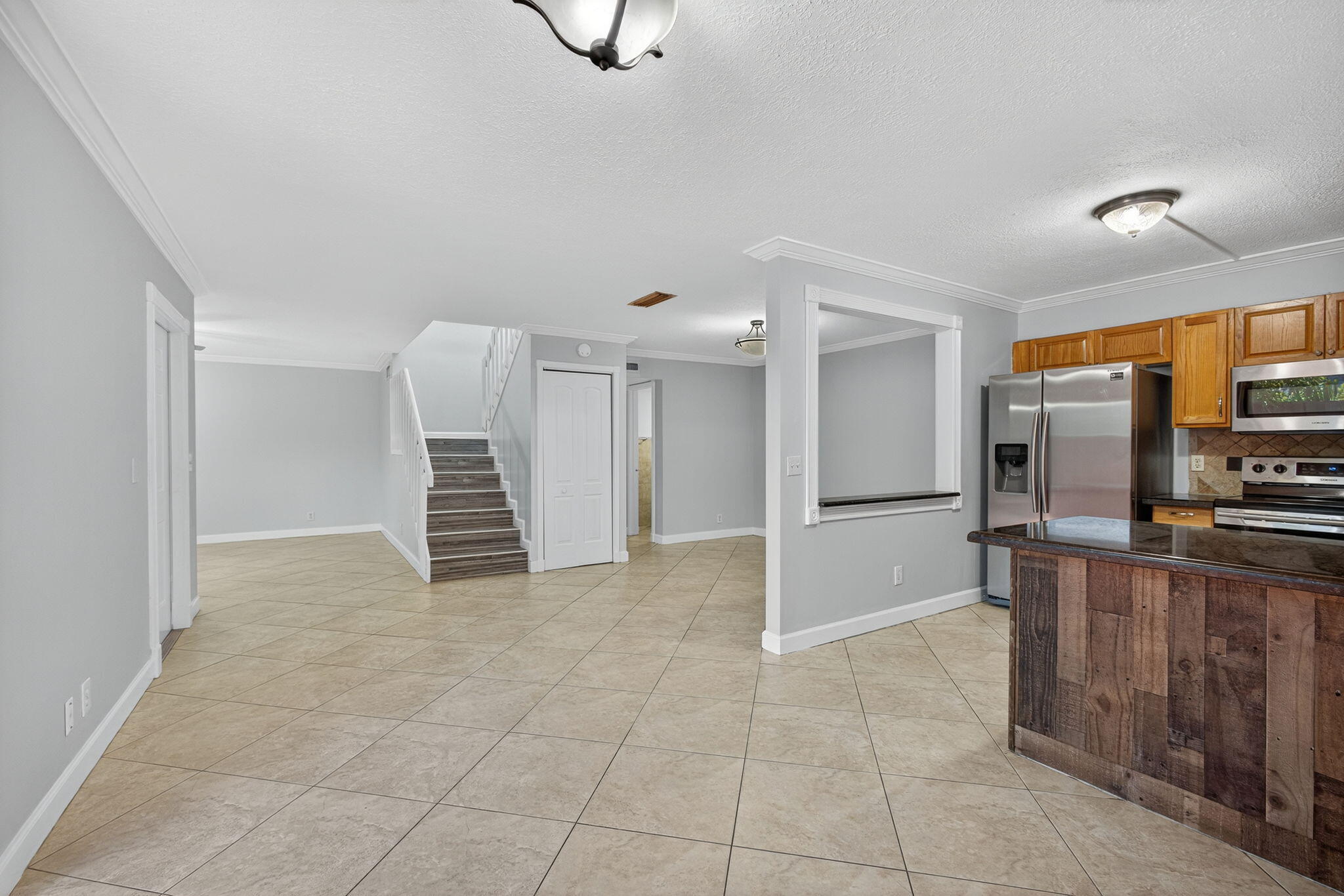 GORGEOUS 3 bedroom, 2.5-bathroom RENOVATED townhome nestled in the vibrant heart of West Palm Beach with a NEW ROOF, New FRONT DOOR and Newer A/C (2023). Meticulously renovated with crown molding throughout the downstairs, captivating farmhouse theme, every corner exudes charm and sophistication. Step inside to discover beauty where every bathroom boasts exquisite tile work and each vanity cabinet has been tastefully replaced. The kitchen is a chef's dream, with nice countertops and equipped with newer stainless-steel appliances.