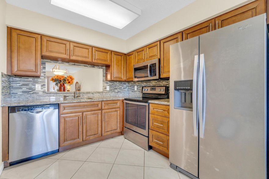 Elegant waterfront condo with modern upgrades. This spacious 2-bedroom, 2-bathroom residence offers a bright and inviting atmosphere, featuring an updated kitchen with granite countertops, stainless steel appliances, and large pantry. Beautiful living -dining area enhanced by the large light diagonal tiles. Expansive large main bedroom with a great sitting area overlooking the water. Nicely updated private bathroom. Large guest bedroom benefits from an additional updated bathroom. The enclosed lanai provides more living space overlooking the lake. An abundance of natural light throughout this outstanding condo. Separate laundryroom for added convenience. NO SPECIAL ASSESSMENTS!!