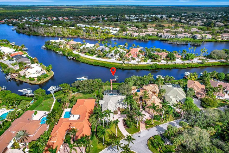 HUGE $200,000 PRICE REDUCTION! BRAND NEW ROOF AND HURRICANE IMPACT WINDOWS! BEST DEAL ON THE RIVER!  8733 SE Compass Island is nestled in the exclusive gated enclave of Compass Island in The Island of Jupiter, on a lushy landscaped 1/2acre+ waterfront estate with expansive views looking directly down the Loxahatchee River. The home features 4 bedrooms, + office. 3 full baths, a 3-car garage, a screened-in heated pool and spa, a summer kitchen under the covered lanai, and a 12,000 Lb boat lift! Low Martin County Taxes! Inside, it's an open floorplan with trayed ceilings, updated kitchen with quartz counters, Mother of Pearl backsplash, marble floors in the living areas and wood in the bedrooms, steam shower, newer AC's.  Priced to sell so don't let someone else buy your waterfront dream hom