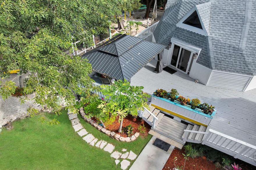 ,*Nightly Rentals allowed with approved Vacation Rental License. - Property Manager** Unique Artisan House sits on 2 1/2 Lots, Surrounded by Tropical Fruit tees and Beautifully Landscaped Grounds. This is a rare peace of tropical paradise. 3 Bed / 2 Baths, Pine Wood Floors, and Soaring Living Room Ceilings. Screened Pergola with Hot Tub, an Enchanting Gazebo Nestled Among Nature, and a Orchid Filled Hammock Nook. Across from a 38 acre preserve. 2 1/2 lots Yard is Completely Fenced with 2 Rolling Gates and there is a Custom Built Shed  Lots of Premier Restaurants within Walking Key Largo Park. Community pool, pickle ball, tennis, volley ball, exercise path and station and more. 45 steps to Boat ramps are 5 minutes away. This private road with only only 3 houses. New Roof.