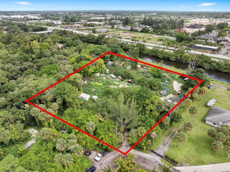 Vacant land. Incredible 5.04-acre waterfront property featuring approx. 3.04 acres of upland and a 2.00-acre private road easement. Fully fenced and gated, with 600 feet of water frontage on the C-51 Canal, a navigable waterway maintained by the U.S. Army Corps of Engineers. Riparian rights included, allowing the opportunity to build a private dock and keep your boat in your backyard. The deeded 60-ft private road offers rare privacy and control. Ideal for adding a gated entrance. No HOA. Located near Southern Blvd and the Turnpike, just 15 mins to PBI Airport. Sail to Lake Osborne. A truly one-of-a-kind, build-ready site in a rapidly developing area. Survey can be found under ''documents''.