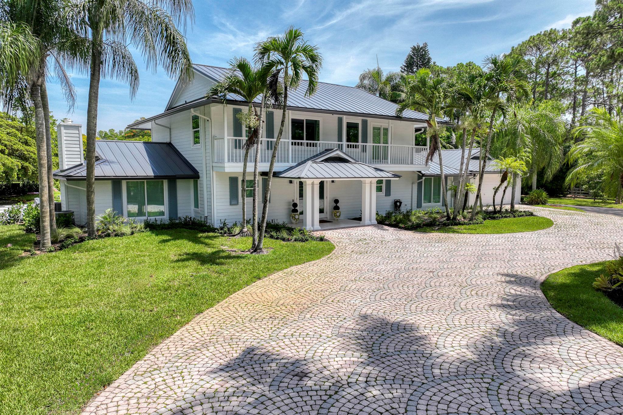 Welcome to a modern French Country estate that is nothing short of spectacular, an Architectural Digest-worthy masterpiece nestled on over 5 pristine acres of South Florida landscape. Completely reimagined with no detail overlooked, this sprawling property offers the perfect blend of timeless European charm and cutting-edge luxury. From the moment you enter, you're met with grand living spaces bathed in natural light, each one more breathtaking than the last. Wide-plank European wood flooring, soaring vaulted ceilings with skylights, walls of glass, and designer finishes create a refined yet welcoming ambiance throughout. The show-stopping kitchen features dual oversized islands, quartz surfaces, custom ceiling-height cabinetry, a statement wood hood over a professional LaCanche range,