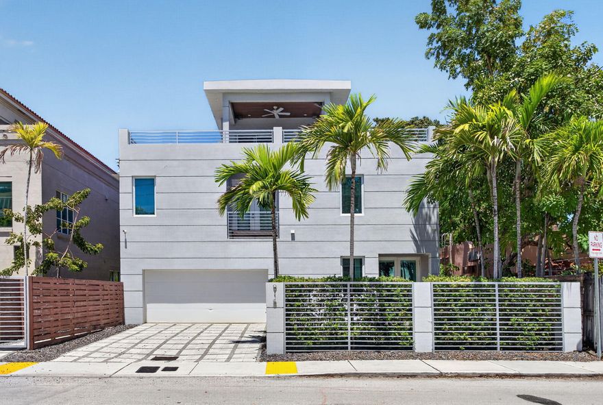 Exceptional modern 3-bed, 4-bath tri-level residence in prime Fort Lauderdale, just blocks from downtown and steps from Las Olas Blvd. The open main level features sleek tile floors and a striking spiral staircase. The chef's kitchen boasts a gas cooktop, commercial-style hood, double ovens, massive stone island, and custom cabinetry. The second level hosts the private quarters, including a sprawling primary suite with wood-plank flooring, a huge walk-in closet, and a spa-inspired bath with floating dual vanities. A third-floor loft opens to a spectacular rooftop terrace designed for entertaining, complete with a covered lounge and built-in summer kitchen. Finished with a gated paver driveway and 2-car garage. A rare architectural standout offering sophisticated urban living. Exceptional modern tri-level residence situated in a prime Fort Lauderdale location, offering sophisticated urban living just blocks from the downtown skyline. This meticulously designed 3-bedroom, 4-bathroom home features an open-concept main level with sleek, large-format tile flooring, anchored by a striking architectural spiral staircase. The chef's kitchen is built for serious cooking and entertaining, equipped with a premium gas cooktop, oversized commercial-style exhaust hood, double wall ovens, an expansive stone island with bar seating, and custom contemporary cabinetry.  The second level is dedicated to the private quarters, highlighted by a sprawling primary suite with rich wood-plank flooring, a massive custom-built walk-in closet, and a luxurious spa-inspired en-suite bath featuring floating dual vanities, modern fixtures, and a seamless glass shower. The secondary bedrooms are bright and generously sized, offering excellent layout versatility.  The crowning feature of this property is the third-floor loft that opens to a spectacular rooftop terrace. Designed for year-round enjoyment and high-end entertaining, this expansive outdoor space includes a covered lounge area with a wood-paneled ceiling, a built-in summer kitchen, and ample open-air space with panoramic city views. Complete with a secure, gated paver driveway, a spacious two-car garage, and striking contemporary curb appeal. A rare architectural standout in an unbeatable location.