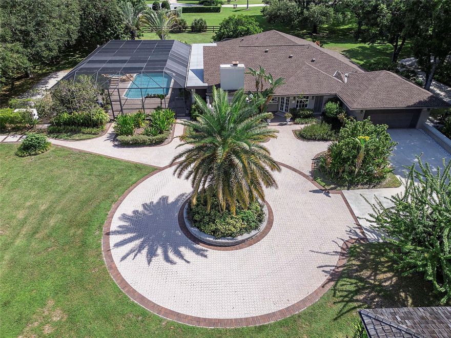 Nestled on over 5 lush acres, this private estate offers luxury and tranquility behind a double-gated entrance. The 3-bedroom, 3-bathroom residence features elegant marble floors, a cozy wood burning fireplace, and all impact windows for peace of mind. A 6-car garage provides ample space for vehicles and storage. NEW ROOF(2023) in main house. FULL HOUSE GENERATOR. Outdoors, enjoy a resort-style pool with spa, summer kitchen, and a serene gazebo. Stay active with a tennis court, exercise station, and scenic track. The grounds are dotted with mature fruit trees, blending beauty with bounty. This property is a rare blend of sophistication, privacy, and lifestyle—perfect for those who crave space without sacrificing comfort.