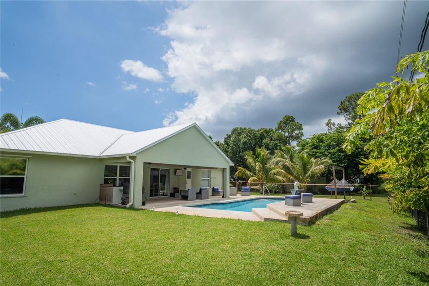 PRICE IMPROVEMENT! Spacious layout-sparkling saltwater pool-make this home an entertainer’s dream!  Jump in the freshly resurfaced, tiled pool with color-changing LED lights and outdoor shower. Open-concept kitchen, dining, and family room provide an ideal flow for gatherings. Split floor plan ensures privacy: the primary suite features tray ceilings, dual sinks, a sunken tub, separate shower, and walk-in closet; the opposite wing offers two guest bedrooms and a cabana bath. Bonus room can be an office or 4th bedroom. NEW Life Proof flooring in bedrooms, NEW metal roof and NEW energy-efficient Lennox Elite HVAC system. DOUBLE LOT offers a 12’ x 24’ shed and ample space for recreational vehicles or expansion. This rare Florida gem blends comfort, space, and flexibility!