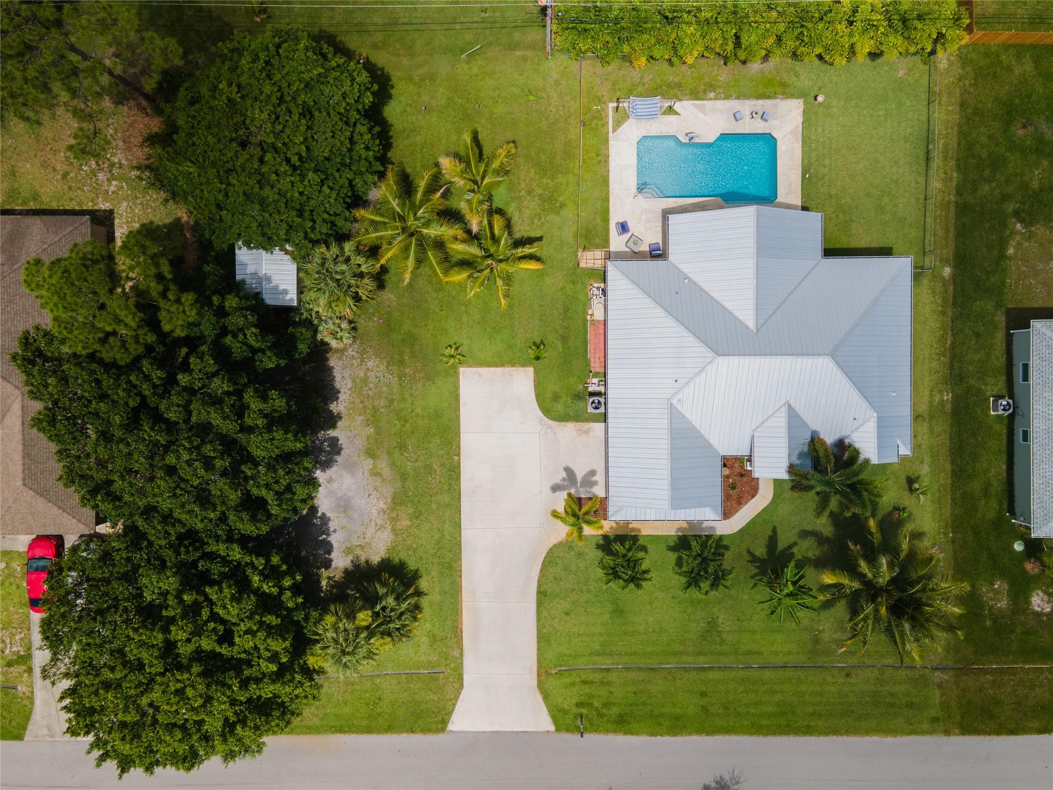 Big Beautiful DOUBLE lot on a quiet street. 1st lot has parking for 12+ vehicles /RV/camper, irrigation, LARGE 12ftX24ft metal roof shed, & mature shade trees. 2nd lot has spacious 3/2 home, NEW metal roof & NEW Energy Efficient Lenox Elite HVAC system. Open-concept kitchen, dining, & family room perfect for entertaining. Split-floorplan offers privacy, anchored by a primary suite with tray ceilings, dual sinks, sunken tub, shower, and walk-in closet. Opposite wing - Two guest bedrooms and a cabana bath. Bonus room can function as an office/fourth bedroom. NEW life proof flooring in bedrooms. LARGE saltwater pool, tiled, freshly resurfaced, color changing LED Lights and outdoor shower. Ample driveway parking 10+ cars. This rare Florida gem won't last. Schedule your private showing today!