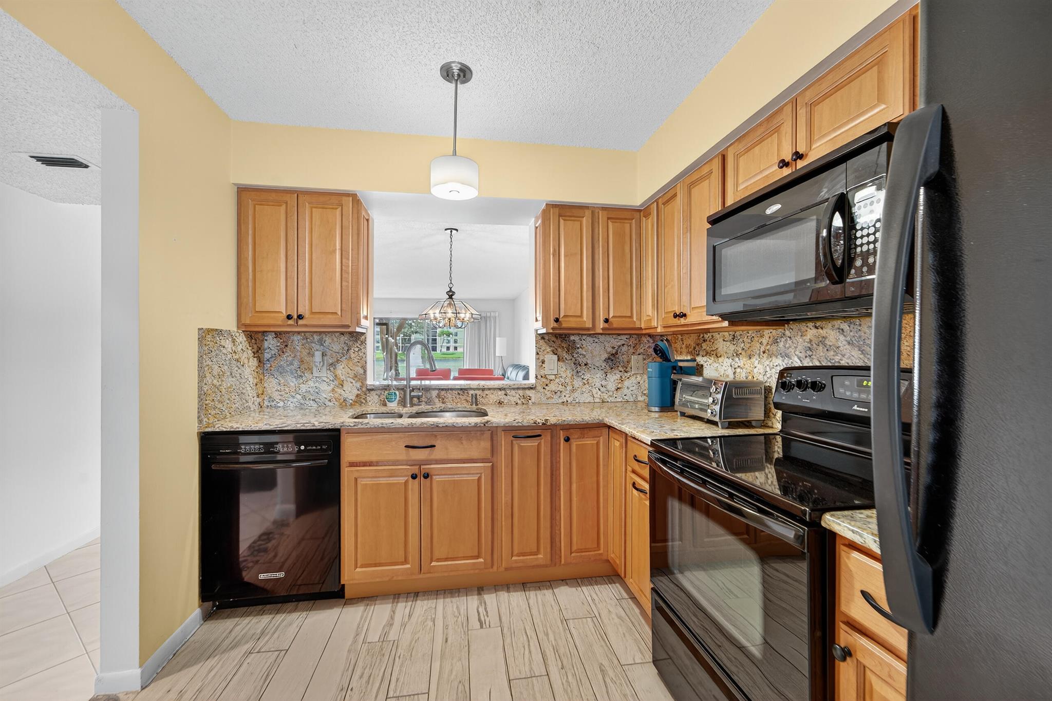 Light, bright, 2/2 condo with Florida room with panoramic lake view. Laundry room inside with full size washer and dryer. Move in as is or make it your own. Sold as is with furniture on premises included. Covered parking space number 22-14. Huntington Pointe is a an active adult community that features a 53,000 square foot clubhouse. The 600 seat theater offers live entertainment and movies year 'round. You also find a fitness center, card rooms, billiard room, aerobics room, bocce courts, pickleball courts, Har-Tru tennis courts (schedules for December of 2025), 4 heated outdoor pools, heated indoor pool, numerous clubs and organized activities, and a cafe that's open for breakfast and lunch every day.