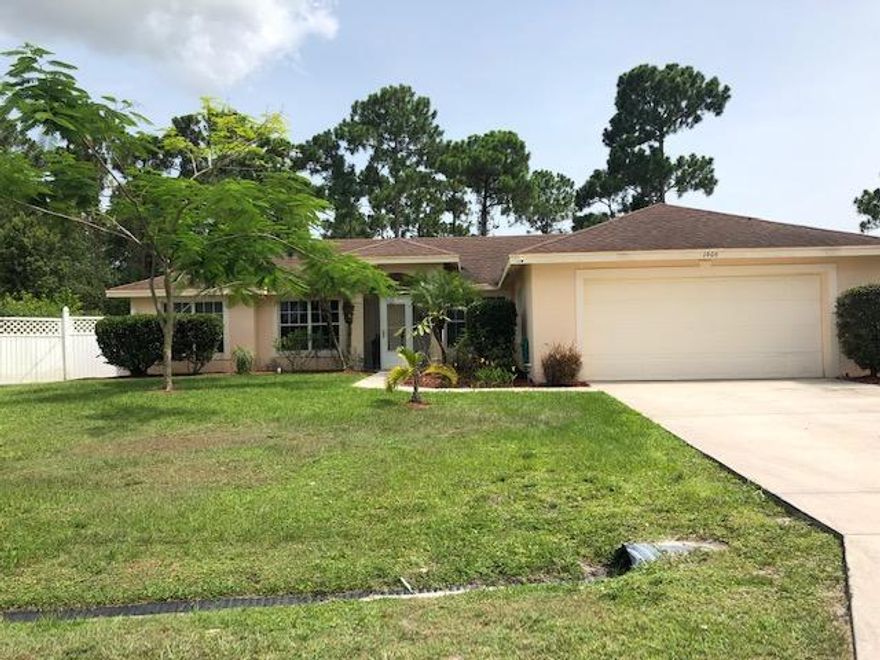 Why wait to build when you can own this wonderful 4 bedroom, 2 bathroom home?  The house features a split bedroom plan with tile throughout living areas and carpet in the bedrooms.  Large open living room/dining room with vaulted ceilings and open shelving to place your decorative touches.  Kitchen has granite counters, ample storage and all stainless appliances.  New refrigerator December 2019 featuring dual ice maker, water and ice at door.  Bead board and crown molding provide a nice decorative touch.  Inside laundry room with newer clothes dryer and brand new washer.  Garage houses hurricane shutters, side garage door for outside access and pull down stairs for attic storage.  Slider from dining room to outside patio as well as slider to screened patio/porch area. All light fixtures remain as do all seven ceiling fans.  Verticals and horizontals throughout.  Front storm door on screened front porch.  Bedroom two has vaulted ceilings.  All bedrooms are spacious and have ample closet space.  Bedroom 4 has decorative shelving to display your treasures.  Guest bathroom features dual sinks, linen storage, built in and combo tub-shower.  Master bedroom has a tray ceiling, 2 closets, 1 walk-in and ensuite with combo tub/shower.  Full linen closet for storage.  Slider out to screened, overhead trussed patio allows for morning coffee relaxation overlooking the tropical paradise pool area.  The property is located on a drainage canal for privacy.  The entire backyard is fully fenced and features a pavered patio area to grill and relax on the hammock or enjoy a swim in the sunken-in above ground salt chlorinated pool.  Lush tropical landscaping surrounds the pool area affording the utmost privacy while inviting butterflies and humming birds.  Schedule your private showing today.  You will be glad you did!