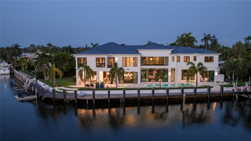 The Crown Jewel of East Deerfield Beach. A sophisticated, Georgian-Inspired Trophy Point Estate sited on 245’ of deepwater on the Kingfisher Waterway with spellbinding panoramic water views. This remarkable estate features 6-bedrooms, 7-bathrooms, two-half-baths with 8,558+/- living square feet. Chic, Modern Interiors include an impressive primary suite with dual bathrooms. Amenities include 48kw generator, 4 bay garage, 5 Zone A/C, Smart Home Automation, office, chef's kitchen and elevator. Outdoor entertainment is enjoyed at the expansive lanai with summer kitchen and resort style heated, saltwater pool with swim up bar and spa. Ideal for the avid boater, there is a full service composite yacht dock capable of docking multiple yachts and is complemented with two(2) boat lifts.