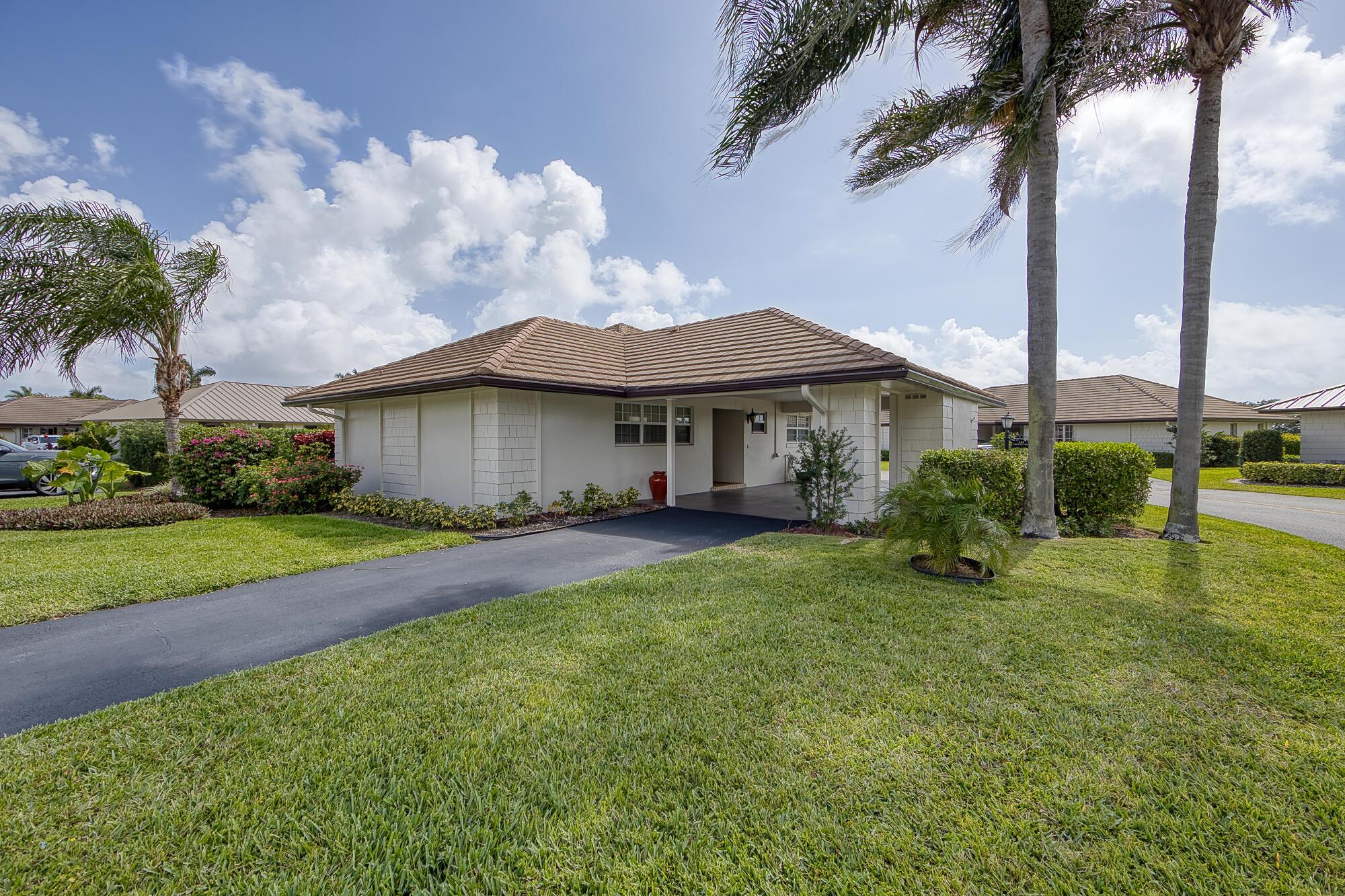 CHARMING 2 BEDROOM, 2 BATH RENOVATED VILLA ON A PREMIER CORNER LOT IN THE GATED CITY OF ATLANTIS!This light-filled villa offers an open, free-flowing layout with a spacious, air-conditioned sunroom--ideal for relaxing, entertaining, or working from home. The beautifully updated kitchen features solid wood cabinetry, granite countertops, and stainless steel appliances. Neutral ceramic tile throughout the main living areas, with warm wood flooring in the primary suite. Additional features include full impact windows, accordion shutters on sliders, a circular driveway, interior laundry room, and ample storage.