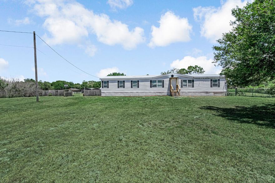 Located in one of the most desirable areas of Montura Ranch Estates, this beautifully maintained 4-bedroom, 2-bath double-wide home offers the perfect blend of privacy, space and convenience. Situated on a partially fenced and gated 2.5-acre corner lot with paved road access. This move-in-ready property is ideal for those seeking peaceful country living with modern comforts. The home features a durable metal roof for long-term peace of mind, along with an updated kitchen complete with modern appliances. Laminate flooring runs throughout and both bathrooms have been updated, including new showers by Bath Fitter.  Enjoy relaxing evenings on the screened-in back porch, perfect for taking in the serene surroundings.  The property also includes two oversized 40' x 18' sheds with electrical amps (50, 30 and 15) plus an additional storage building, providing ample space for equipment, hobbies or workspace. Additional highlights include an updated water filtration system, an added light pole for enhanced nighttime visibility. With no HOA restrictions and horses permitted, this property offers flexibility for a variety of uses. Ideal for entertaining or investment, this property presents excellent short-term rental potential (Airbnb) in an up-and-coming area. A rare opportunity to own a versatile property with land, lifestyle and income potential all in one. Centrally located approximately 90 minutes from Fort Lauderdale, West Palm Beach, Fort Myers, and Miami. Have access to the pool and clubhouse at no extra cost.  Property is grandfathered for mailbox access at the Montura Ranch Estates clubhouse; new properties require a P.O. Box in town.