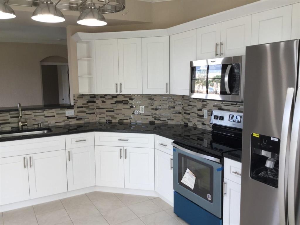 Lovely 2/2 immaculate CORNER condo with lake view. Fully remodeled. NEW custom kitchen with retractable cabinets, beautiful granite, brand NEW kitchen appliances(whirlpool), NEW AC unit (installed 2 weeks ago, which will be reflected in you FPL account very favorably). NEW wood laminate floors, NEW carpet in bedrooms. Crown molding and baseboards that give it a very elegant atmosphere(NEW). This unit has one of the BEST locations and is a must see! The complex features resort style amenities including clubhouse, BBQ area, pool, spa, tennis, and fitness center. You don't have to get in your car, a short walk from the unit are the shops at Legacy Place. The beautiful Gardens Mall, restaurants and movies are close by. Convenient to area beaches, I-95, PBI Airport .