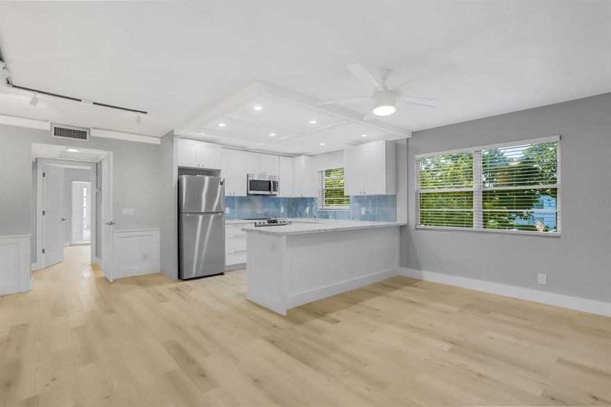 EXQUISITE CORNER 1 bedroom, 1.5 bath condo, COMPLETELY renovated with a modern open-concept design. Stunning kit features white custom shaker cabs, quartz counters, porcelain backsplash, recessed ltg & Samsung ss appl. Luxury vinyl plank flrs thru-out, complemented by elegant crown molding & custom wainscoting accent walls. Smooth knockdown ceilings add a clean & contemporary touch. Primary bedrm has spacious six panel closet doors. Other upgrades incl new A/C, water heater & electrical panel & plumbing. Remodeled bathrm w/shower, porcelain tile &  a beautiful pebble flr!  Enjoy the many amenities incl a lavish clubhouse, pools, tennis, pickleball, putting green, cafe, billiards, shows, clubs, classes, theater, movies & much more! DON'T MISS THIS GREAT OPPORTUNITY! Assoc. Claims 55+