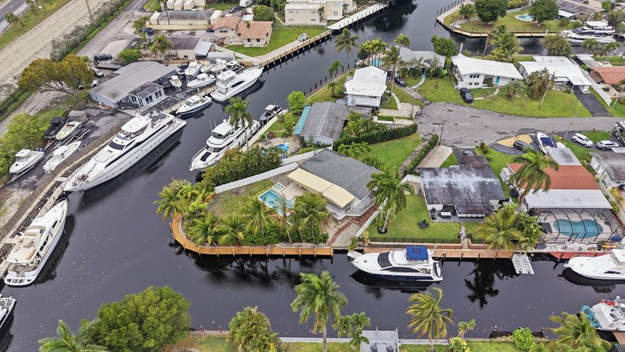 Incredible Opportunity in Fort Lauderdale! 11,400 SF lot for a Boaters Paradise on a rare point lot featuring OVER 150 feet of deep waterfront on canal & New River. 30/50A electric and water in 3 diff spots on the dock. Unrestricted ocean access and NO fixed bridges. Park up to 3 vessels or even a catamaran right in front of your 3 bedroom 2 bath split level home! Incredible lot with lots of grassy area. Kitchen features quartz countertops, soaring ceilings, impact windows throughout. Enjoy the patio overlooking a custom heated pool and spa, plenty outdoor seating with incredible privacy. Side access allows for ample parking and separate entrance to the dock. Lush tropical landscaping, on one of the largest lots in Lauderdale Isles is the epitome of Florida's lifestyle.