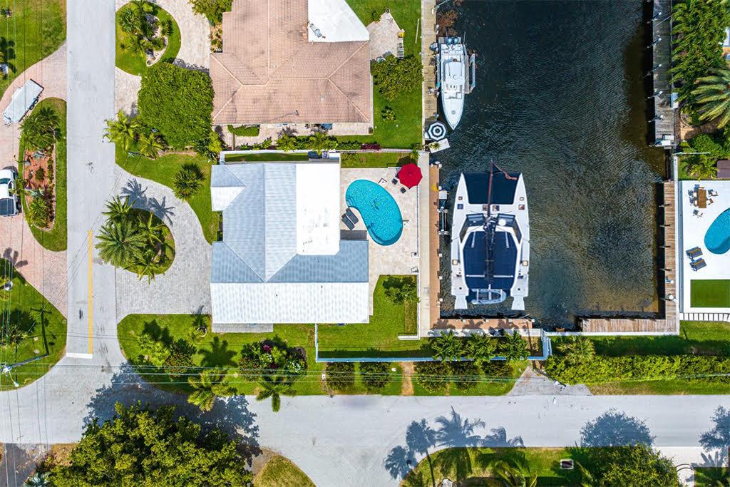 Bring your Big Wide Boat!! L shaped dock affords side and rear boat access. The Owners have spent the last year thoroughly and completely updating a great Premium Waterfront property into an incredible home that rests along 122' of Dock-lined Deep Waterfront. 2 boats fit! No fixed bridges w/ the Ocean minutes away. Contemporary and modern finishes from flooring to custom ceilings w/the major components all new or recent including the Roof, Impact Windows, Electric, Seawall, Dock, AC, & Lift. Abundant upgrades including new kitchen and baths, glossy seem-less ceilings, a wet/coffee bar, custom 2 car AC Garage. Southern exposure on a faultlessly designed pool & patio ideally compliment a raised stone deck and cable railings that lead down to a 100'+ modern wrapped concrete dock.