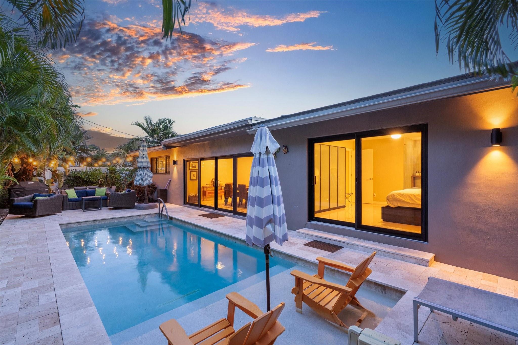 Gorgeous and move-in ready! This Coral Heights gem features glistening large ceramic tile, impact windows, and spacious bedrooms. The open kitchen offers abundant cupboard space and stainless steel appliances, flowing seamlessly into a formal dining area with full pool views and high hat lighting. Beautifully updated bathrooms and plantation shutters on most windows add comfort and style. Outdoors, enjoy a fenced backyard, sparkling pool with sundeck, and a private front porch perfect for morning coffee or evening wine. Located in a no-HOA area, this home includes a primary suite with a bonus split A/C—ideal for those who love it cool at night.