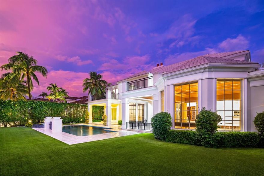 THE BEST WATERFRONT VALUE in the prestigious Royal Palm Yacht & Country Club. Featuring 95-feet of direct water frontage on the highly desirable street of East Coconut Palm Road, this two-story, 6,433-square-foot estate includes six bedrooms, seven full baths and one half bath. The elegant architectural treatment outside yields to a spacious interior that seamlessly bridges that worlds of comfort and sophistication. Interior highlights include front and rear staircases, a sprawling library/office with dramatic built-in shelving and wet bar, a two-story formal living room, and a relaxing family room with beamed ceilings and towering windows that invite natural light. In addition, an upstairs theater room boasts stadium seating and a bar area. This brand new gourmet kitchen includes state-of the-art appliances, quartzite countertops with waterfall features, a large walk-in pantry and custom cabinetry throughout. The first-floor master suite with sliding glass windows opens up to the heated pool and spa area, along with two covered patios that overlook Butterfly Palm Waterway. The inviting master bath features a large walk in closet, a soaking tub, and a shower that exudes privacy. The estate also features impact glass windows and doors, four-zone air conditioning, natural gas, automatic shades, a generator that serves the entire house, and a private dock with shore power and LED lights. Lush tropical landscaping throughout the property set the scene for the ultimate intimate tropical escape.The front circular marble driveway leads to a three-car garage constructed with built-in storage cabinets. Priced to sell.