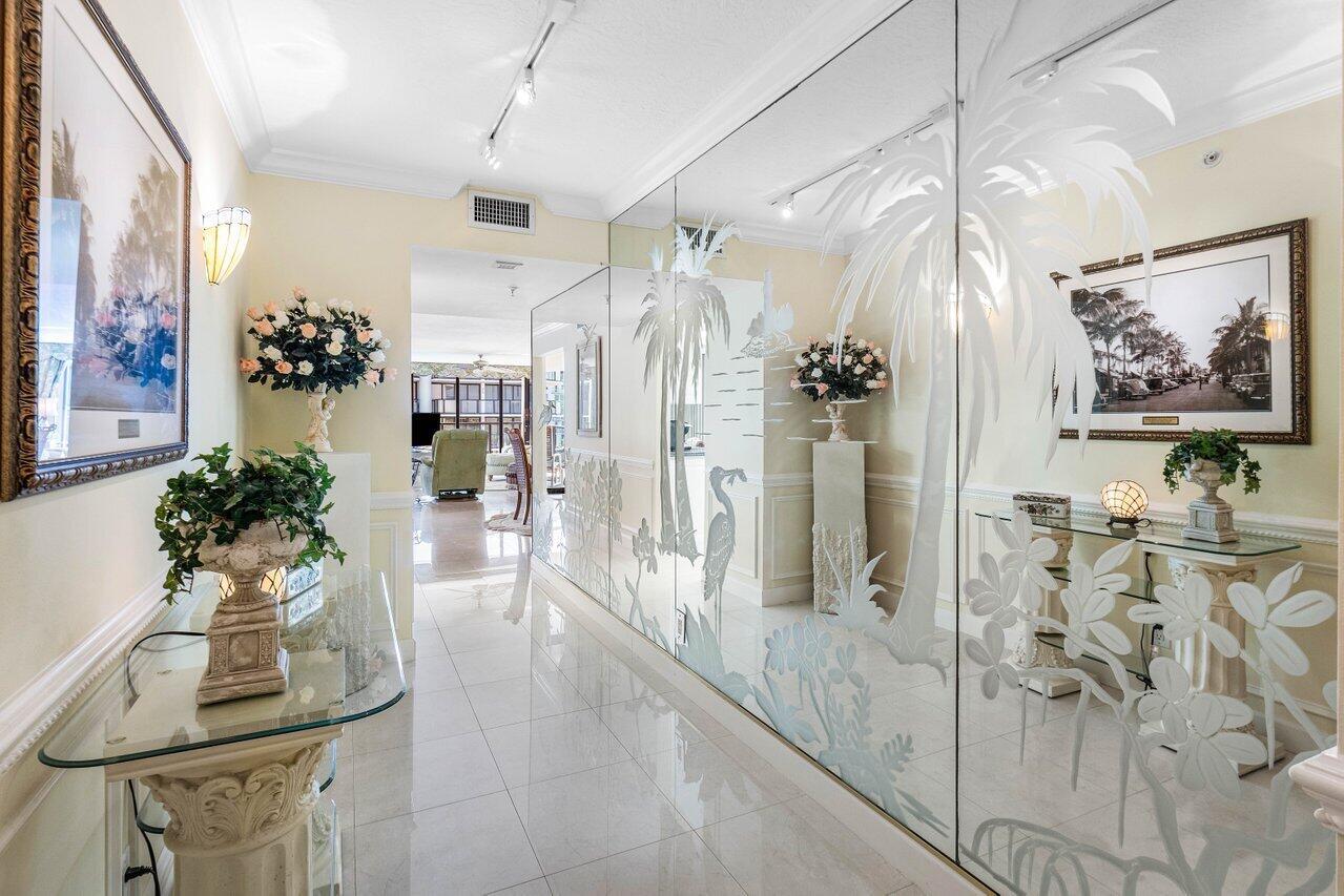 This elegant residence, says ''Palm Beach,'' and greets you with breathtaking views of the sunrise to sunset. Nestled on the 5th floor of the Halcyon's North Building, this spacious two-bedroom, two-bathroom floor plan boasts two glass balconies that offer stunning Southeast Ocean views and panoramic vistas of the Intracoastal. Step inside and you'll be enveloped in a meticulously maintained property. Hurricane-impact doors and glass ensure the safety, while a custom eat-in kitchen, a custom bar with beautiful back-lit etched accent glass, wainscoting walls, custom cabinetry, and attractive stonework add to the home's charm. The Halcyon, where this residence resides, offers a range of amenities to enhance your stay. Enjoy the convenience of 24/7 doormen, a resort-style pool area and beach,