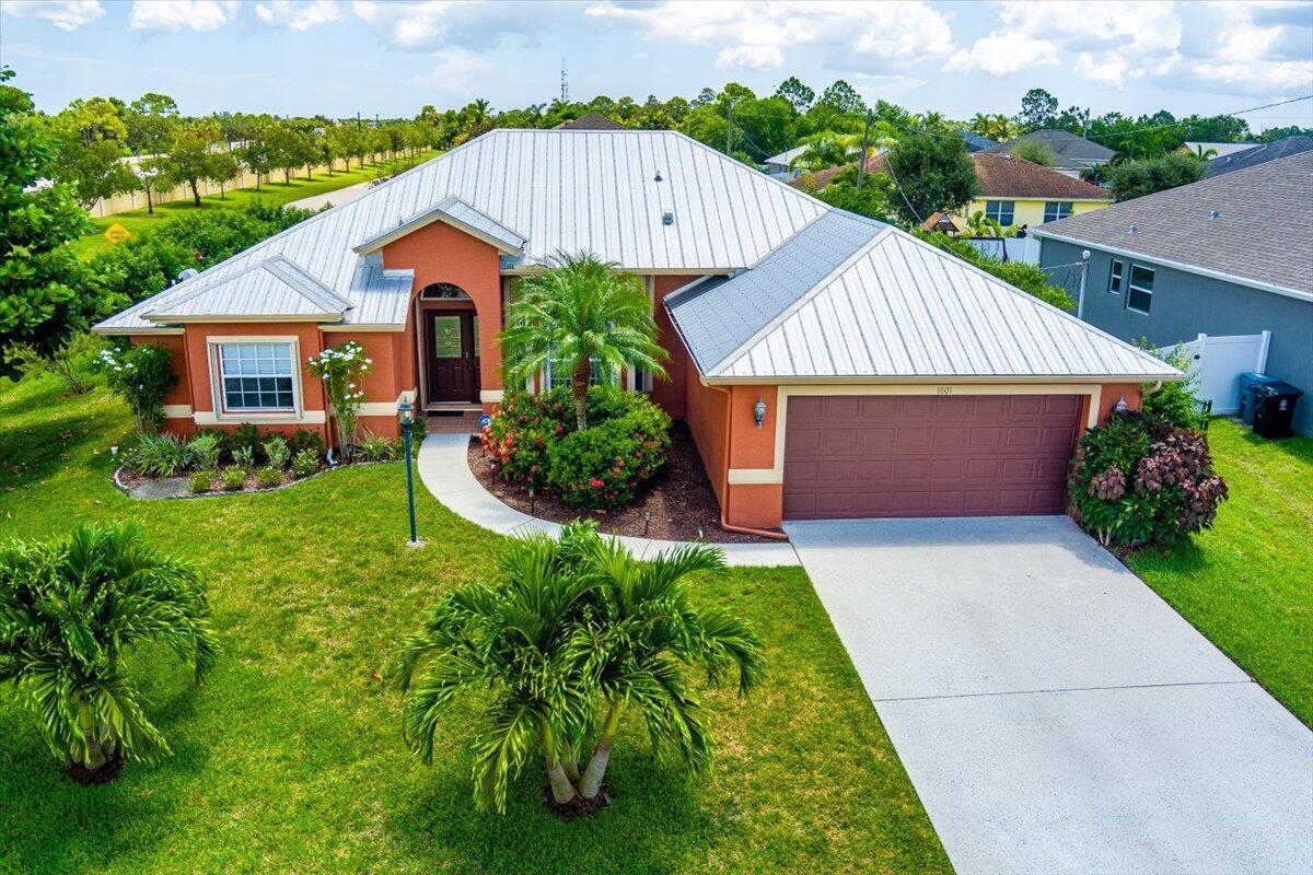 Beautiful 3BR+Den, 2BA pool home on an oversized corner lot just minutes from Tradition, with NO HOA! Features include updated kitchen with 42' cabinetry with crown molding, soft-close cabinets, granite counters, newer stainless-steel appliances, wood-look tile throughout, large laundry room, oversized pantry and separate living/dining areas. The Den is perfect for a home office or can be a 4th bedroom. Cabana bath opens to a beautiful, newly resurfaced screened pool with a newer pool pump. Fenced yard with lush landscaping, large covered Patio, 2019 metal roof, 2022 accordion shutters, and built-in sound system makes this home perfect for Florida living. Prime location near shopping, dining, and entertainment! Don't miss the opportunity to own this move-in ready home!