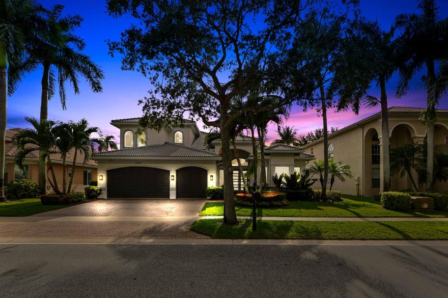 Welcome to a beautifully updated & waterfront residence in the desirable Boynton Beach community of Canyon Isles. Set among lush tropical landscaping and peaceful lake views, this home immediately captures the feel of South Florida living. The home makes a striking first impression with its fresh exterior presence, brand new roof, full impact windows & doors, spacious driveway, and inviting entry, offering a warm blend of curb appeal, privacy, and everyday comfort in a well-kept neighborhood setting.  Inside, the home feels bright, open, and sophisticated with soaring ceilings, large windows, plantation-style shutters, and warm wood-look flooring that flows through the main living areas. The home also boasts the primary suite & 3 guest bedrooms on the first floor along with 3 full bathrooms. The second floor includes a huge loft space, full bedroom & bathroom.  The living room offers an elegant focal point with a sleek media wall, while the fully updated kitchen brings a clean modern feel with glossy white cabinetry, quartz-style countertops, a stylish backsplash, and warm lower cabinetry that adds texture and contrast. All bathrooms have been newly updated adding a fresh, spa-like touch with contemporary tilework, a glass-enclosed showers, and modern finishes.    Outside, overlooking the beautiful lake, is an entertainers dream with a free-form pool & spa that has been newly resurfaced and upgraded tile added, travertine decking, summer kitchen, and separate screened patio area.  Thoughtful upgrades make this home even more appealing, including a new roof with spray foam insulation, impact windows, 3 new AC units, all new bathrooms and a full home generator with a 500 gallon propane tank, giving buyers confidence and move-in-ready convenience. With large bright bedrooms, generous closet space, refined finishes, and a serene Boynton Beach location close to shopping, dining, recreation, and everyday essentials, this home offers an enticing opportunity to enjoy comfort, style, and the relaxed lifestyle South Florida is known for.
