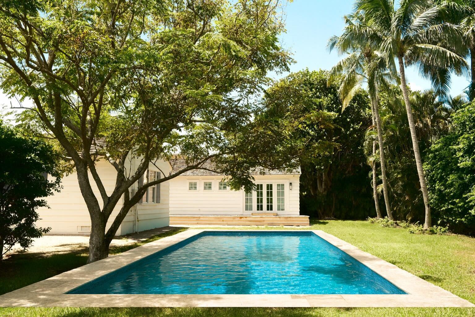 Just one block from the beach and a short stroll to Atlantic Avenue, this one-of-a-kind residence sits on one of the most private and expansive corner lots in the prestigious Seagate neighborhood. Originally built in 1948, it is one of the few remaining Old Florida charm homes -- now brought back to life through a painstaking three-year renovation led by the award-winning Chris Leighton Design Group. The result is a timeless masterpiece that blends classic soul with modern luxury. Step inside and be transported to another era, where meticulous craftsmanship meets contemporary comfort. Wide oak hardwood floors anchor light-filled interiors, while marble countertops, Buster + Punch brass switches, and thoughtfully curated mood lighting add layers of detail. New pool completed November 2025