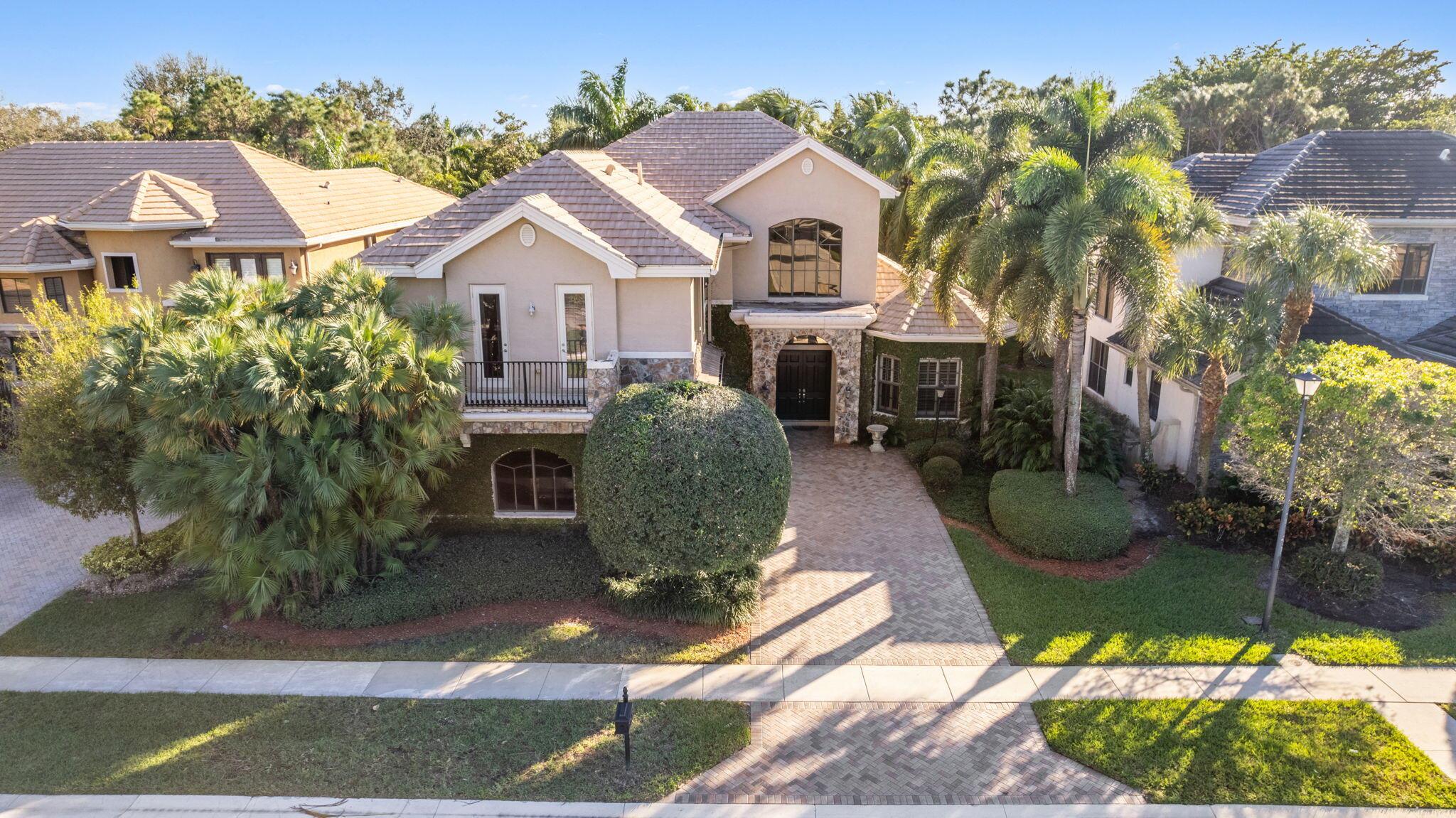 An exceptional estate home located within the prestigious guard gated community of Versailles. The ultimate in curb appeal, this home boasts soaring 22ft ceilings that frame FABULOUS views of the lush, tropical, PRIVATE backyard. The floorplan has spacious living areas, a formal dining room, an elegant office, and a downstairs guest suite. This chef's kitchen is a DREAM which features granite slab countertops, upgraded cabinetry, stainless steel appliances, gas cooktop and double ovens. Take the elegant staircase to the stunning Primary Suite which is enhanced by a custom walk-in closet, dual vanities, and separate shower and tub. Interior upgrades include crown moldings throughout, wood flooring in select areas, French doors and accordion shutters for added security.