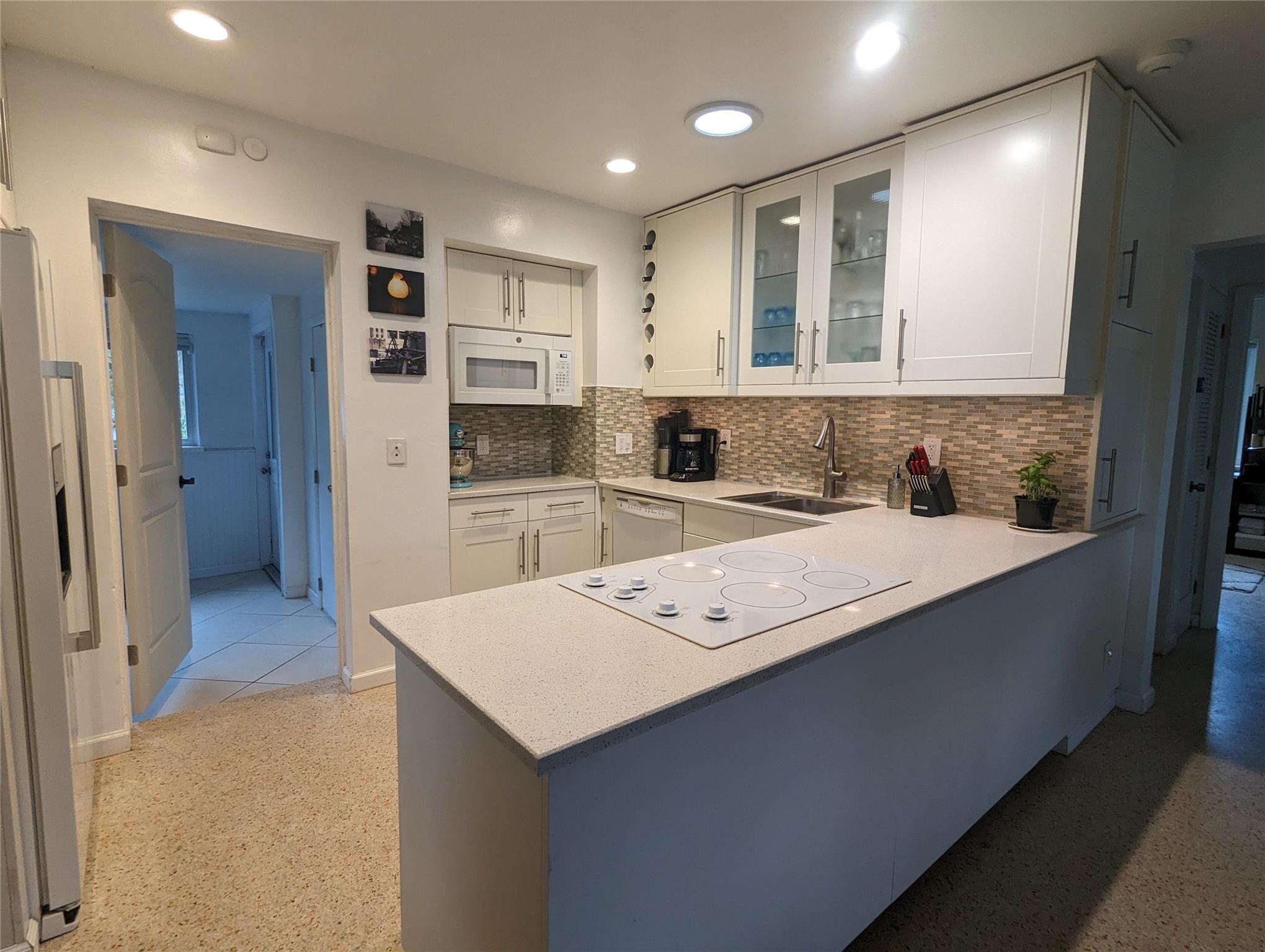 This Key West Style Florida Home features newer kitchen cabinetry, appliances, glass tile backsplash, quartz countertops and a skylight. Boasting an open floorplan with gorgeous terrazzo floors throughout and urban contemporary style bathrooms. Energy efficient hurricane impact windows and doors with a cozy screened-in porch for your enjoyment. Revel with your family or guests in a large back yard w/ tropical landscaping and an 8-person jacuzzi! Located 2 miles to the beach, walking distance to shops, bars & restaurants on 13th Street and Wilton Manors. Close to downtown Fort Lauderdale and easy access to I-95! Come make this your new home!