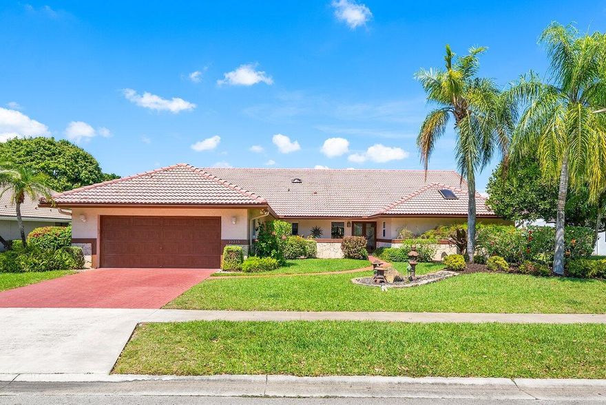 Located in Boca Woods Country Club, this 3 BD 2.5 BA home enjoys stunning golf course views and a convenient layout. Enter into a stunning living room with cathedral ceilings and an abundance of natural light pouring in through expansive sliding doors. The space flows effortlessly into the dedicated dining area. The kitchen is centered around an oversized island and overlooks a second living room and breakfast area, all lined with bright windows that enhance the home's light and airy feel. The spacious primary suite offers direct access to the pool through sliding glass doors, along with two walk-in closets and a beautifully appointed bathroom complete with a sunken shower, soaking tub, and a private water closet for added privacy.  Two additional bedrooms share a well-designed Jack and Jill bathroom, and a convenient walk-in laundry room adds to the home's thoughtful functionality. Outdoors, a vast covered patio with an outdoor kitchen creates the perfect setting for alfresco dining and shaded relaxation. The pool and spa are surrounded by lush palm trees, with serene golf course views completing this private outdoor oasis.
