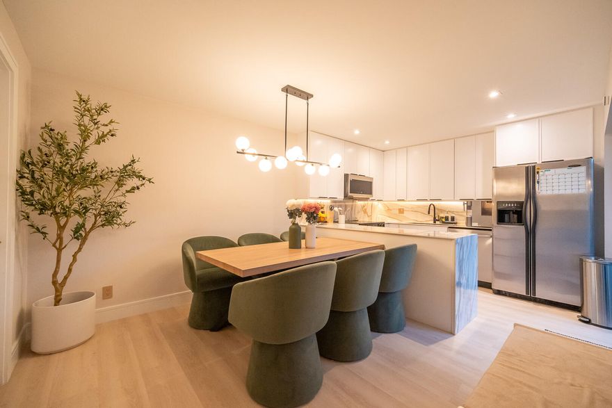 This beautifully updated unit features a bright open-concept layout, sleek contemporary kitchen with custom cabinetry, quartz countertops, stainless steel appliances, and stylish lighting fixtures. The full-height quartz backsplash adds a seamless, high-end look, while under-cabinet lighting enhances both ambiance and practicality. The oversized island offers abundant storage and seating space, making it perfect for entertaining, casual dining, or family gatherings. Light wood flooring and designer lighting tie everything together, creating a bright, sophisticated, and move-in-ready kitchen that truly serves as the heart of the home. The living and dining areas flow seamlessly, creating a perfect space for both everyday living and entertaining. Both bathrooms have been tastefully renovated with modern vanities, updated tile work, and elegant fixtures. The spacious bedrooms offer comfort and functionality, while the overall design showcases clean lines, neutral tones, and high-end touches throughout. Move-in ready and designed for today's lifestyle, this townhome is the perfect combination of style, comfort, and quality craftsmanship. Beautiful private outdoor space designed for both relaxation and family fun. This fully fenced patio features low-maintenance artificial turf, creating a clean and green look year-round. The covered seating area with retractable awning provides shade and comfort, perfect for entertaining or enjoying peaceful mornings outdoors. Surrounded by lush tropical landscaping and palm trees, the space offers privacy and a true South Florida feel. There's plenty of room for outdoor furniture, a grill station, and even a dedicated play area, making it ideal for families or anyone who loves indoor-outdoor living. A rare find spacious, functional, and inviting backyard-style patio that extends your living space beautifully.