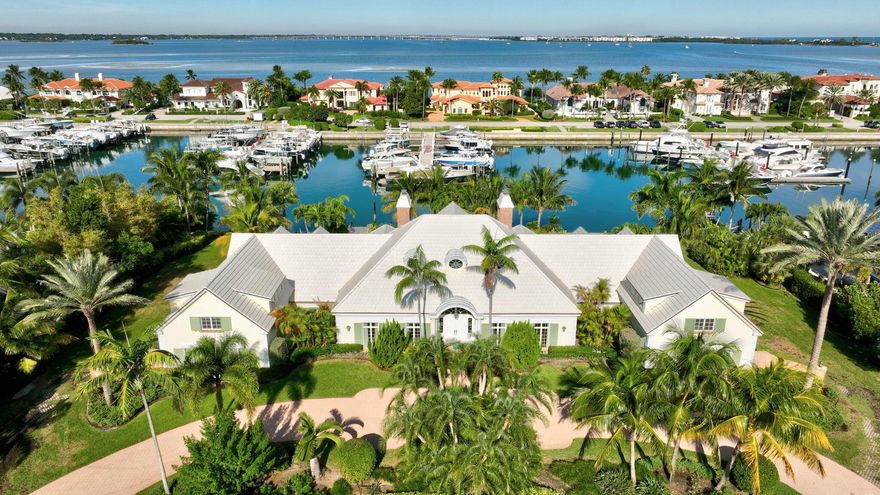 Set on a rare double lot in the prestigious, gated enclave of Sailfish Point, this stately home offers timelesspresence and exceptional waterfront potential-approx 230 ft on the water and dock that may accommodate a largevessel-this is a boater's paradise! Grand curb appeal leads to a main residence offering 5 bedrooms, 5 full and 2half-baths, within 7,020 sf of living space. A dramatic great room with fireplace, ideal for elegant gatherings, isenhanced by a marble foyer, volume ceilings, and formal dining room. The kitchen features an island, gas cooktop,and casual dining, opening to a family room and Florida room. Two separate 3-car garages are crowned by twoprivate guest apartments, each with bedroom, bath, living area, and kitchen. Sailfish Point delivers an unparalleled