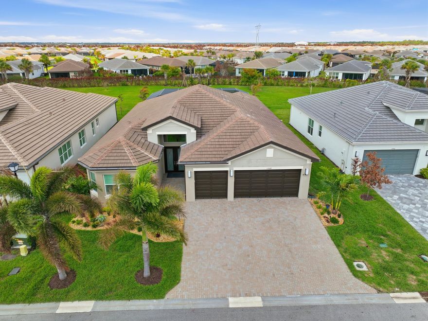 Own a beautifully designed & professionally landscaped home that shows like a model. Enter into a grand foyer with a luxurious faux-painted walls, soaring ceilings, continuous crown molding & sophisticated wallpaper with a polished modern tile flooring. This exquisite 3-bedroom, 3.5-bathroom home also features a versatile office & a full 3-car garage. Every detail has been thoughtfully considered, including a whole-house water filtration system. The open-concept floor plan flows seamlessly into a sleek white  kitchen, boasting Level V cabinetry with pull-outs, under-cabinet lighting, a custom pantry, quartz countertops, a full-height marble backsplash & a center island perfect for both casual meals & formal entertaining.  The primary bedroom offers elegance & views of stunning heated pool and spa.  Enjoy double walk in custom closets and a large en-suite bathroom.  Two additional bedrooms are also en-suite.  Open up those electric blinds to a seamless indoor-outdoor lifestyle, complete with a summer kitchen, gas heated pool & 6 person spa, under an expansive patio lanai with travertine tiles.  Living in Valencia Grove means enjoying the full Riverland experience: world class amenities, vibrant social clubs, miles of pathways, and access to the 55+ lifestyle that makes this community so desireable.  Easy access to major highways, beaches, fine dining, airports and medical facilities.