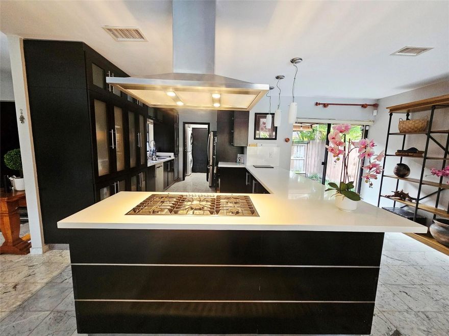 Welcome to this stunning updated pool home in a prime Miami location! This 3-bedroom, 2-bath residence features soaring ceilings, marble floors, and a bright open-concept layout ideal for modern living. The chef’s kitchen boasts a large waterfall island, gas cooktop, custom cabinetry, and designer lighting. The spacious primary suite opens to the backyard and offers a spa-style bath with dual vanities and walk-in shower. Enjoy true Florida living in your private oasis with a heated saltwater pool and hot tub, lush tropical landscaping, and covered patio. Major upgrades include a 2019 roof, 2020 A/C, and hurricane shutters. Quiet cul-de-sac, 2-car garage, move-in ready! Call listing agent for a tour.