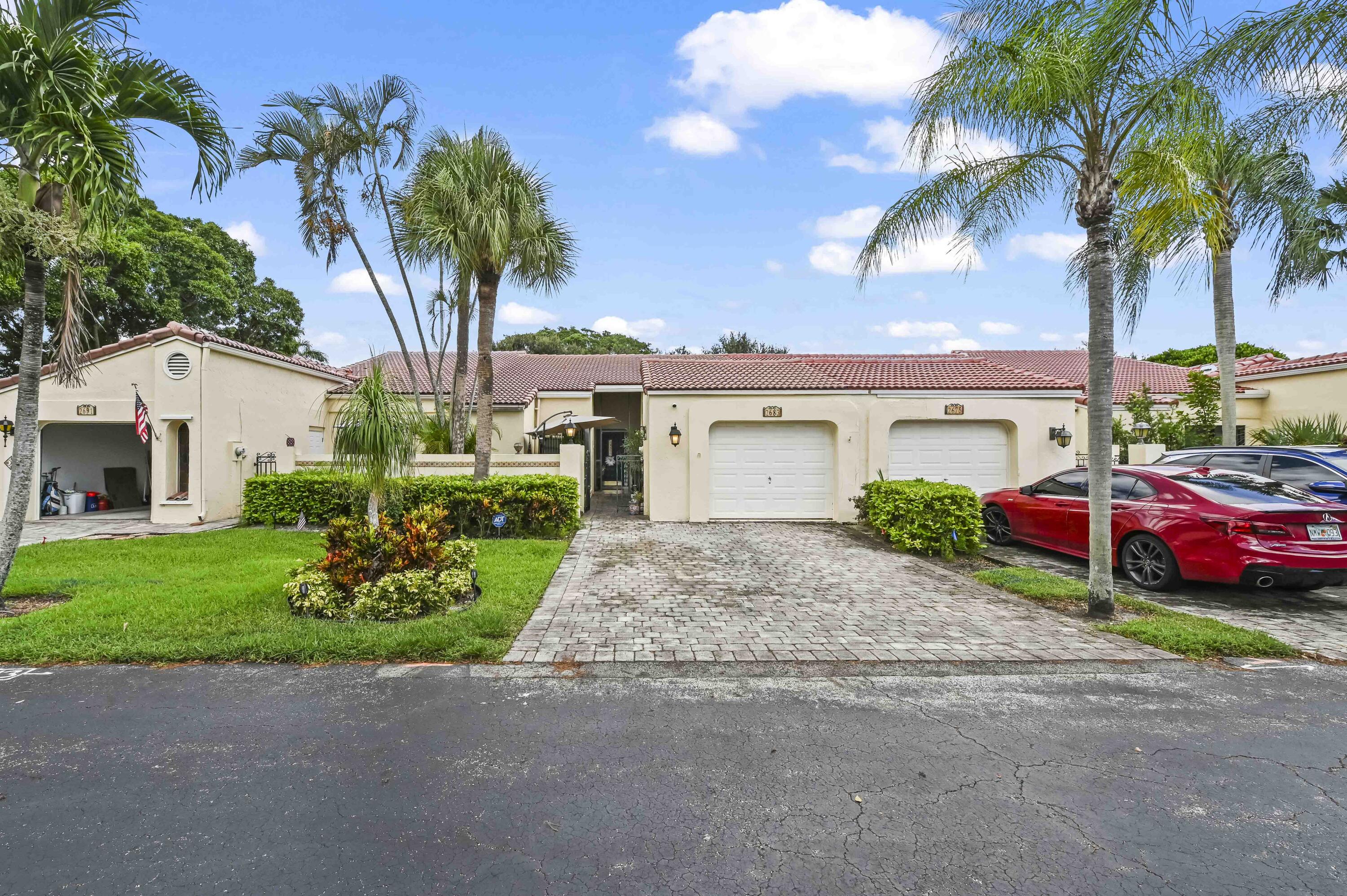 Experience Florida lifestyle in this beautifully maintained 2-bedroom, 2-bath villa, perfectly situated in the sought-after community of Villas on The Green within Deer Creek. Designed for seamless indoor-outdoor living, this home offers serene golf course and garden views that create a tranquil backdrop for your daily life. Inside, soaring vaulted ceilings and strategically placed skylights fill the space with an abundance of natural light, while elegant tile flooring flows continuously through the living, dining, and kitchen areas, creating a bright and inviting atmosphere.
