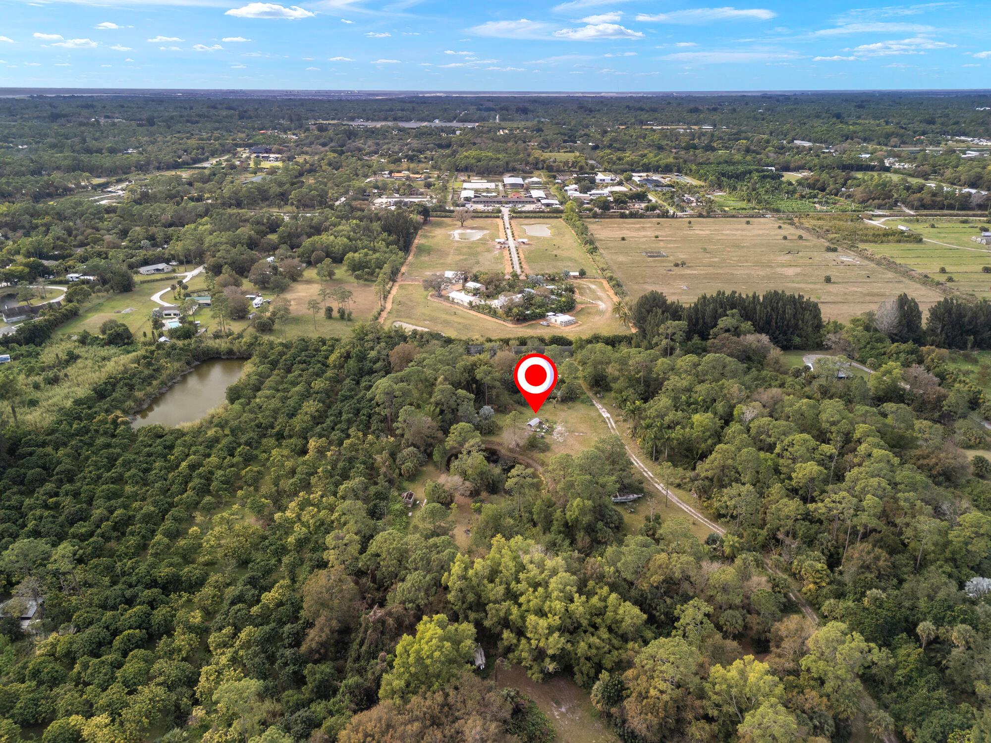 Here's a great opportunity to own 5.5 private acres in Loxahatchee Groves. Previously used as plant nursery, there are still a few shade houses with plants on the back of the property. In addition, there are some really great, mature palms and bromeliads planted on the property. Also, a lovely pond is on the property. There is a well and electric. You really have to see it to appreciate all the possibilities here. A survey has been completed and is available upon request.