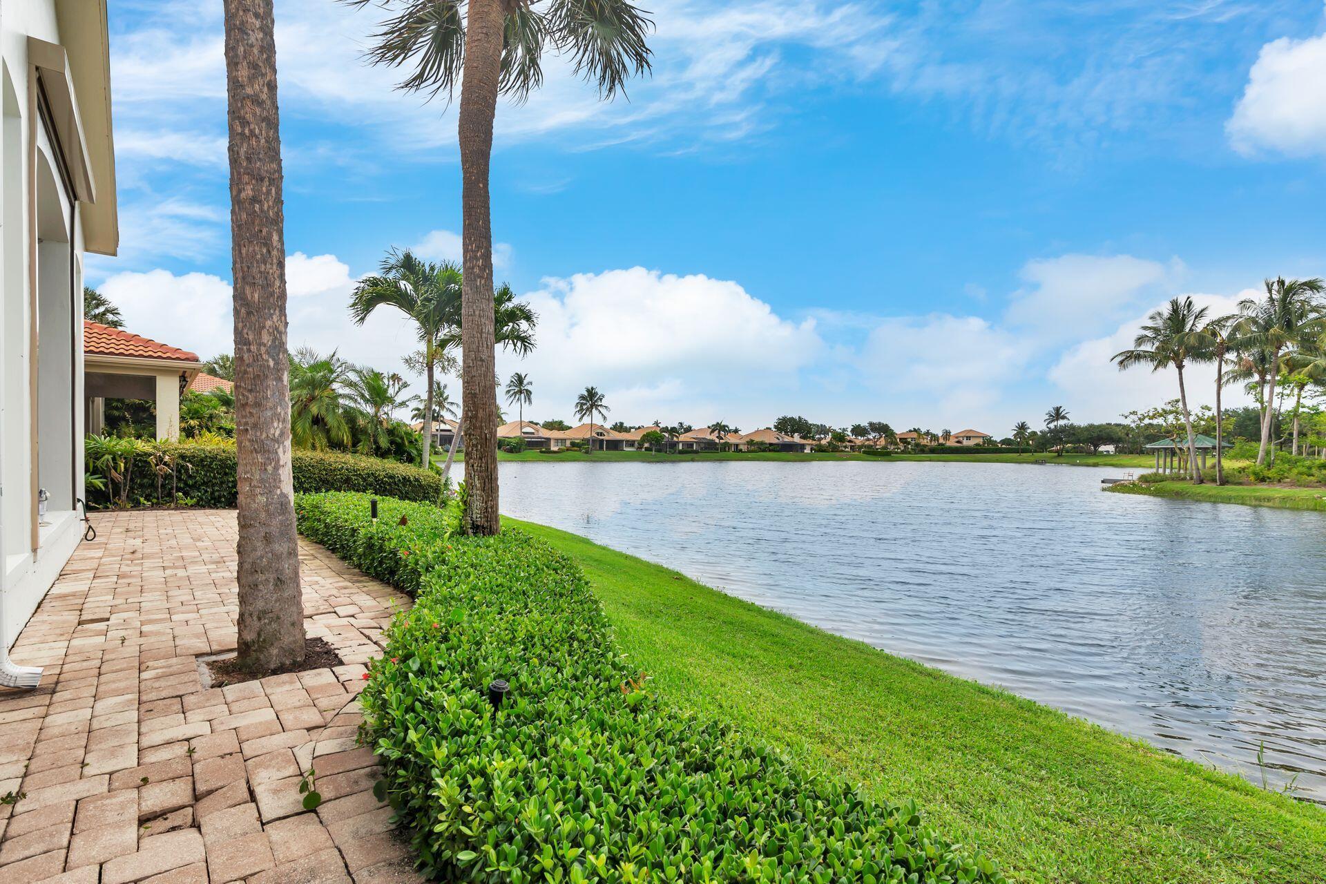 Unmatched Lakefront Views in Lantern Bay - Jonathan's Landing. Quite possibly the best lakefront view in all of Jonathan's Landing, this rarely available 3-bedroom, 3-bath home in Lantern Bay is a true gem. Perfectly positioned to capture panoramic, unobstructed views straight across the wide lake to tranquil Butterfly Island, the scenery here is nothing short of breathtaking--and the kind of peaceful beauty that's impossible to replicate. Step inside and be immediately drawn to the expansive wall of impact glass framing the view like artwork. The open living and dining areas are flooded with natural light, seamlessly connecting to a spacious screened and covered lanai where you can relax or entertain while soaking in the spectacular setting. The chef's kitchen opens to a cozy