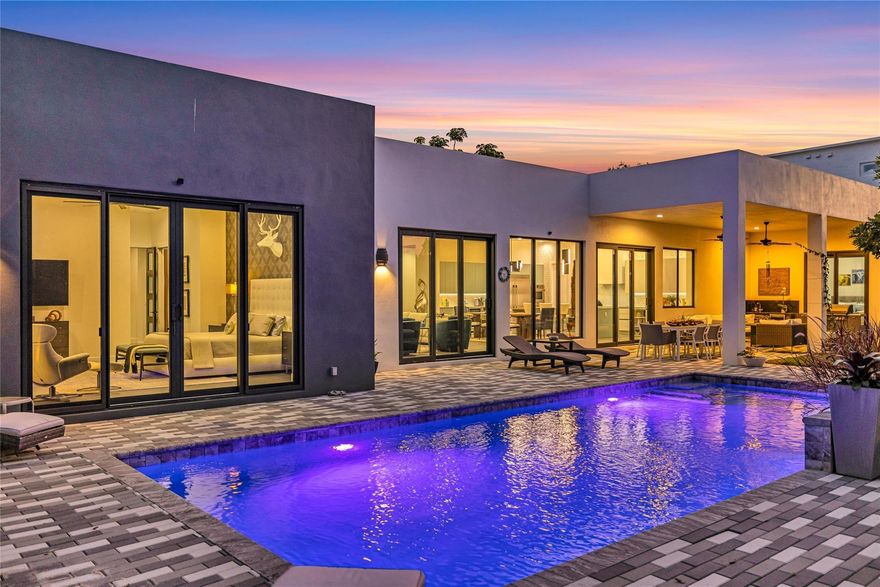 Steps from world famous Wilton Drive, this stunning Wilton Manors estate is tucked on a quiet no pass-thru street on an oversized 15,621+ S/F lot. Featuring 4 large en-suite bedrooms—including a private in-law suite with separate entrance and kitchenette—plus an additional den/office. This architectural masterpiece blends space, style, and luxury. Enjoy soaring 12 ft ceilings, 5 ft wide hallways, and 9 ft solid-core French doors throughout. The European chef’s kitchen offers 25+ ft of quartz counters, premium appliances, and a 11x4 island with built-in butcher block. Outside, your private resort-style yard features a heated saltwater pool, tranquil koi pond, lush tropical landscaping, and plenty of space to entertain or simply relax in total privacy. Timeless | Intentional | Unforgettable