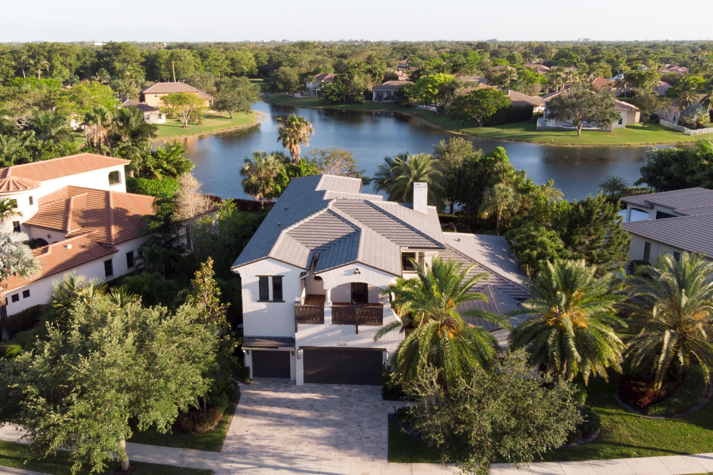 Extensively upgraded and professionally landscaped with private lake views, 6835 Long Leaf Drive is a hidden gem near a quiet cul-de-sac in beautiful Parkland, FL. Featuring an expansive open floor plan with soaring 20' ceilings and cutting-edge upgrades throughout, this 6-bed, 5-bath, 4,840 sq. ft. home is move-in ready. The kitchen is outfitted with Thermador appliances and modern cabinets with quartz countertops. The backyard is a park-like oasis with niches for lounging, working, and entertaining, along with elegant LED landscape lighting. New travertine pavers have been installed throughout the oversized driveway and expanded backyard pool patio. Recently added or upgraded features include a new roof, two new HVAC systems, a pool and hot tub heater and salt water system,