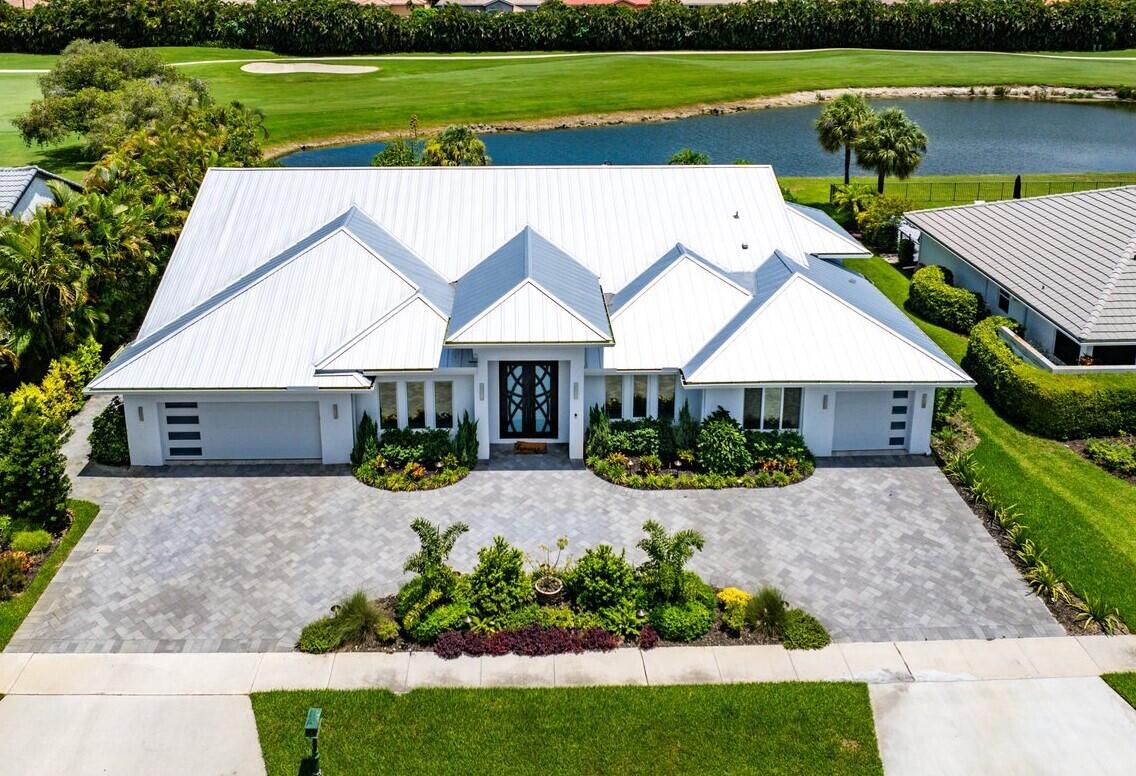 Dream Every Dream in This Private Country Club Retreat! Welcome to your ultimate sanctuary in this 4,200+ sq. ft. home which has everything you could want and more! Contemporary renovation & new construction enlarged custom home located on one of the best large lots -lake & golf course views, no homes behind - total privacy! Enjoy a resort-style backyard with pool & spa, summer kitchen, cabana bath & covered seating area. Perfect home for entertaining. The property, front and back, has been landscaped to create a serene setting during the day with palms, flowering trees and bushes. At night, energy efficient decorative lighting makes this home sparkle. Inside, a chef's kitchen with Thermador appliances & Taj Mahal quartzite countertops, WINE room, bar, OFFICE with custom cabinetry, and 3