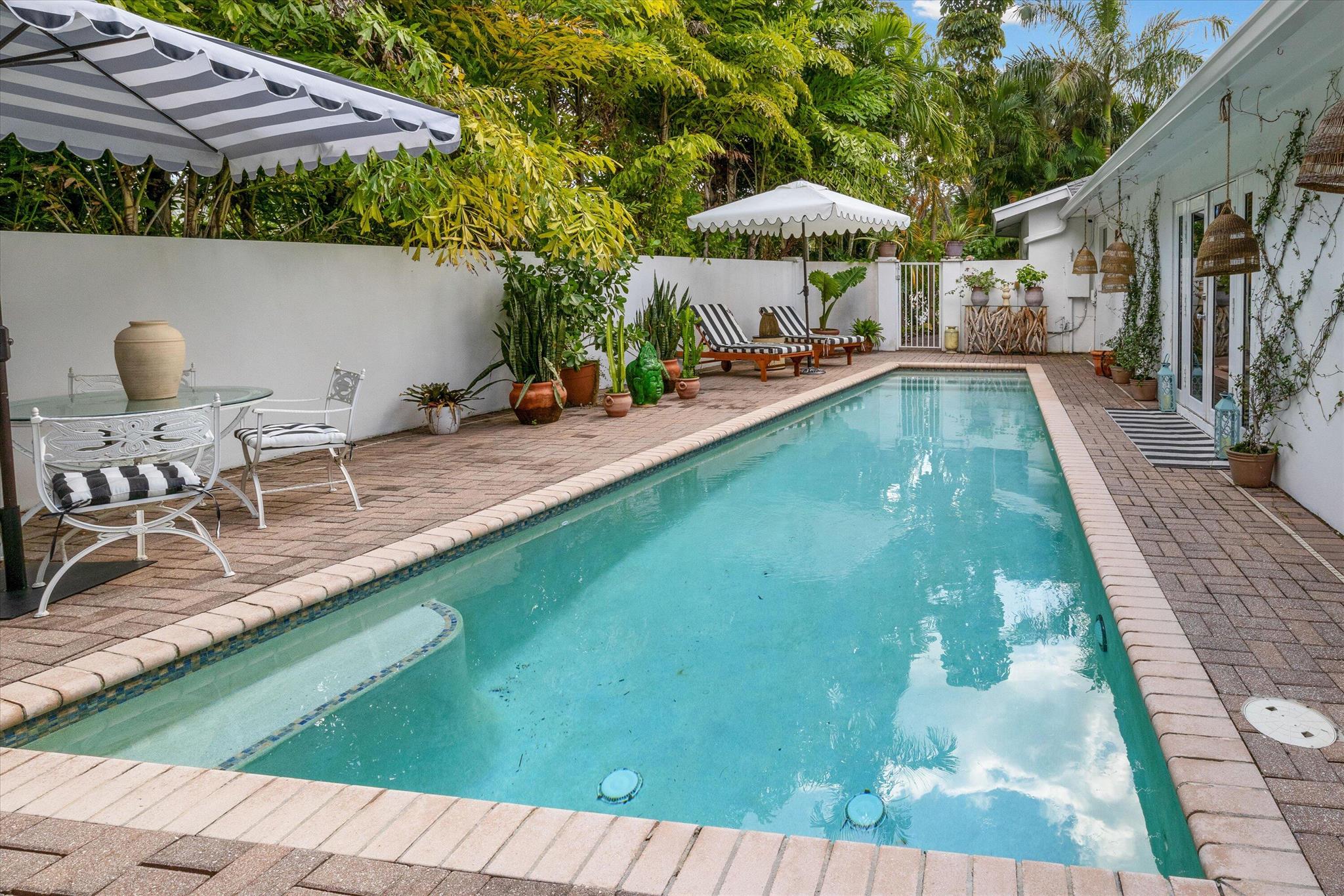 Stylish Mid-Century Modern Home in Highly Desired Northwood. CORNER LOT w/ PRIVATE POOL. Unique spiral staircase leads to ROOFTOP DECK w/ stunning INTRACOASTAL VIEWS! Offered for Unfurnished Annual lease starting Dec 1. This remarkable 3/2 blends classic charm & modern comfort. Inside, a spacious living room boasts French doors that lead to your private outdoor haven. The outdoor space features a saltwater pool, brick paver patio, & lush garden--a perfect place to unwind & entertain. The interior is equally impressive, w/ an open layout featuring formal dining room, well-equipped kitchen w/ breakfast bar, & elegant terrazzo floors. Bonus storage room, brick paver driveway, & more. Walk to Northwood Village & Intracoastal. Short drive to beaches/shops, PB Island, PBI, I-95, & downtown WPB.