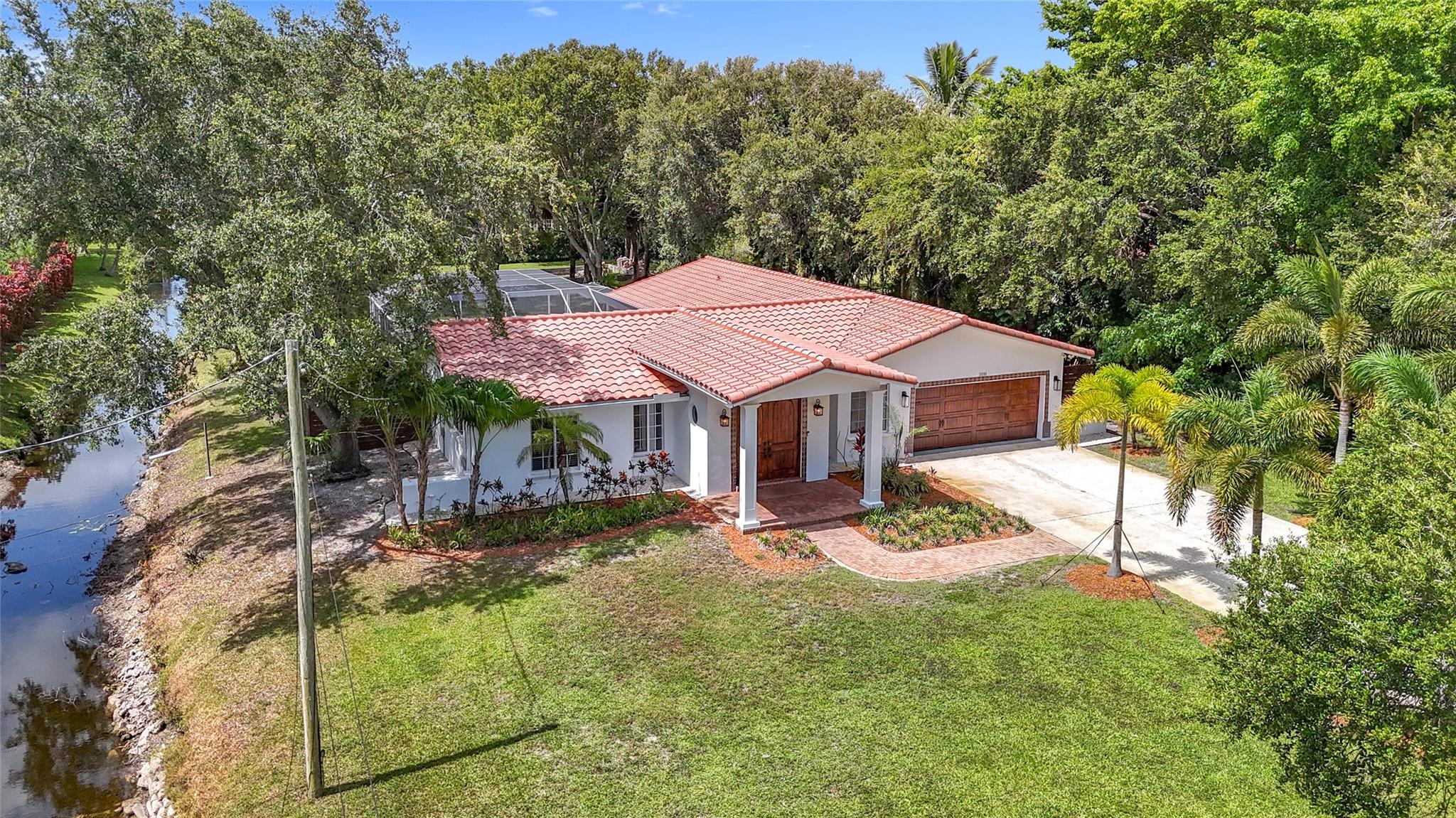 Discover this beautiful home nestled in the heart of Plantation Builders Acre on a generous one-acre lot along a quiet street adjacent to canal. West of 118 AVE. Enjoy the convenience of being close to upscale shopping, fine dining, and easy highway access. Families will appreciate the excellent local schools, including American Heritage school. Open concept living and dining area flows seamlessly into a modern kitchen complete with an island and all offering a tranquil view of the pool. The home is designed with impact windows and doors for added safety and energy efficiency. Fruit Tree two-car garage with new epoxy floor, Planty parking in driveway and there’s even space at the rear of the house to build a guest house. EZ access to highway. waking distance to American Heritage school.