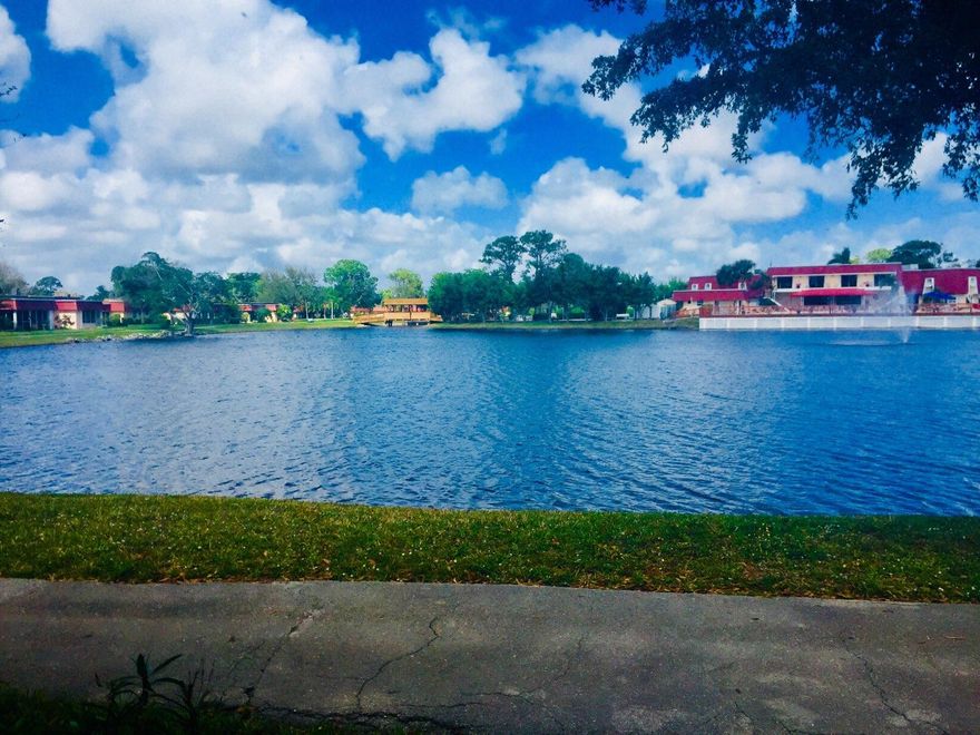 **REDUCED by $10K**ENJOY THE ULTIMATE WATER VIEWS!! This freshly painted & rarely available lovely 2/2 condo, the largest E Model, boasts breathtaking views of the huge lake, covered bridge, fountain & pools  Ceramic tile throughout! Tranquil walking paths surround the complex & lakes with plenty of green to enjoy! Super Friendly development with numerous planned activities, lighted tennis courts, billiards, 2 heated pools with lounges, picnic tables, shuffleboard, & so much more! Small dogs under 20 lb. welcome!  Roof, AC only 7 years old! HOA includes ALL but electric! Very conveniently close to shops, restaurants, major highways, & just a short drive to the ocean! Accordian hurricane shutters, recessed lighting! Park right outside your door! Come ENJOY! AS-IS listing