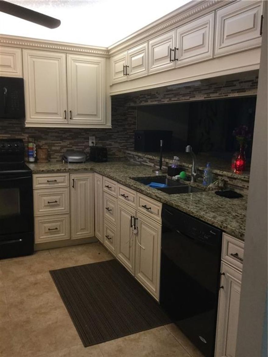 Back on the market due to Buyers loan. Remodeled corner unit in gated community is lovely! Almost 1500 SF of beautiful upgrades include Kitchen cabinets, granite counters, crown molding, chair railing, organized closets and gorgeous tile floors, except in 2 bedrooms that are carpeted. New AC is less than one year. Added benefits of Florida room/den, hurricane accordion shutters and house alarm. Huge laundry room and lots of storage space. Horizontal blinds on all windows and 4 ceiling fans make this home light and bright. Cable, water, tennis and pool included. The community reserves are a little under the 10% lender requirement, therefore a buyer would need 25% down or be able to secure a first mortgage and a 2nd mortgage totaling the 25% down in order to close on the purchase.