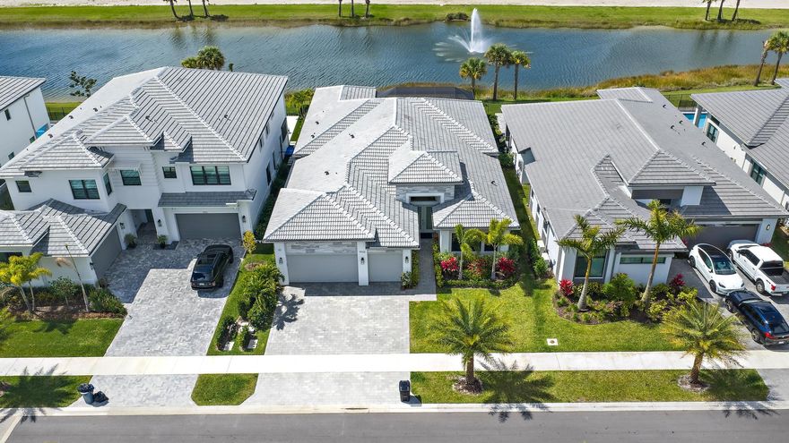 Better than new and exceptionally upgraded, this stunning Adonis model in Apex at Avenir offers refined modern design, premium finishes, and breathtaking west-facing water views with unforgettable sunsets. Situated on a prime waterfront homesite, this single-story residence blends architectural drama with thoughtful livability across 4 bedrooms, 4.5 baths, a private den, and a true three-car garage. From the moment you enter, soaring 14- to 15-foot ceilings in the foyer create an immediate sense of grandeur and light. A custom-designed, walk-in wine room serves as a striking focal point upon arrival -- an elegant statement that sets the tone for the home's elevated aesthetic. Expansive impact windows flood the interiors with natural light, while 12- to 13-foot ceilings in the great room, kitchen, and primary suite enhance the spacious, open-concept design.

The chef's kitchen is both sophisticated and functional, showcasing stacked cabinetry, premium Sub-Zero and Wolf appliances, quartz countertops, and a dramatic apron-edge island designed for gathering. Upgraded 24x24 porcelain tile flooring flows seamlessly throughout the main living areas, complemented by electric roll-down blinds, custom drapery, and fully customized closet systems.

Indoor-outdoor living is effortless with an extended screened lanai finished with pavers, offering tranquil water views and the perfect setting to enjoy South Florida's legendary sunsets. Every detail has been curated to create a residence that feels polished, current, and magazine-worthy -- yet warm and inviting.

Located within Apex at Avenir, residents enjoy access to resort-style amenities, including clubhouse facilities, fitness, pools, tennis, pickleball, scenic trails, and proximity to the forthcoming Avenir Town Center -- all within one of Palm Beach Gardens' most dynamic new master-planned communities.

This is modern Florida living at its most elevated -- turnkey, highly optioned, and impeccably executed.