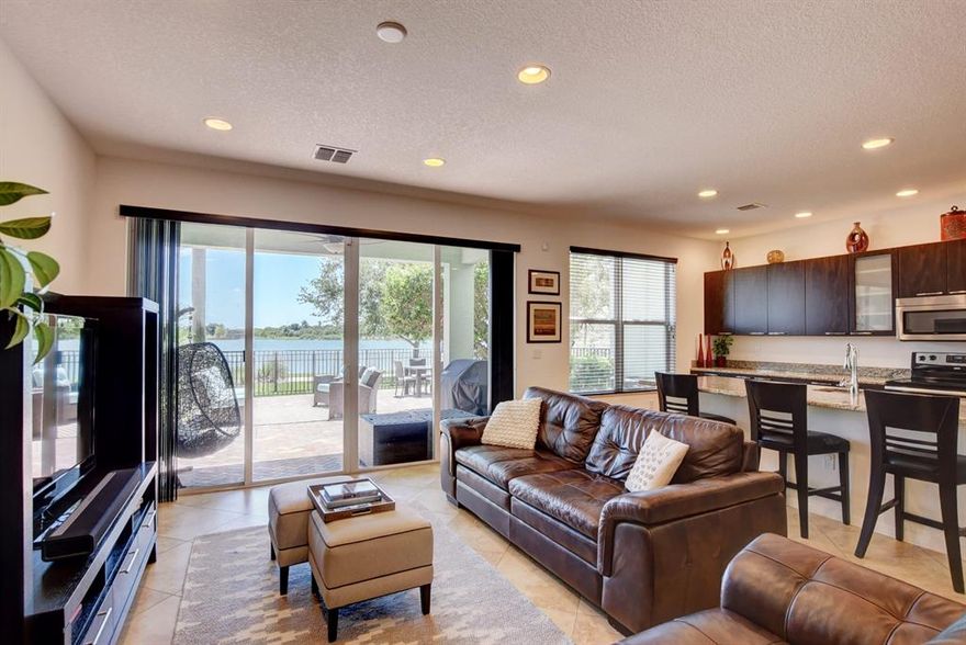 LAKEFRONT MODEL TOWNHOME, ELITE GATED COMMUNITY.   9' ceilings OPEN CONCEPT Living, dining, gorgeous kitchen, granite island, designer floors, guest bath. Lake view from entire living area. Step to the private tumbled-marble paver patio for quiet/relaxing BBQ, outdoor living & amazing view. It's all about the LIFESTYLE! Upper level: huge master suite w/extra large bath & walk-in closet, 2 more large bedrooms/2nd bath, bonus area that can be used as you choose and laundry room.2-1/2 car garage. The Clubhouse and pool/recreation area are nearby and have all of the amenities - Secure child play area, giant pool, hot tub/jacuzzi, workout facilities and upscale Clubroom. This new home is FURNISHED. Centrally located to major roads, the mall, fine dining, Starbucks, Einsteins, & Lifetime Fitness