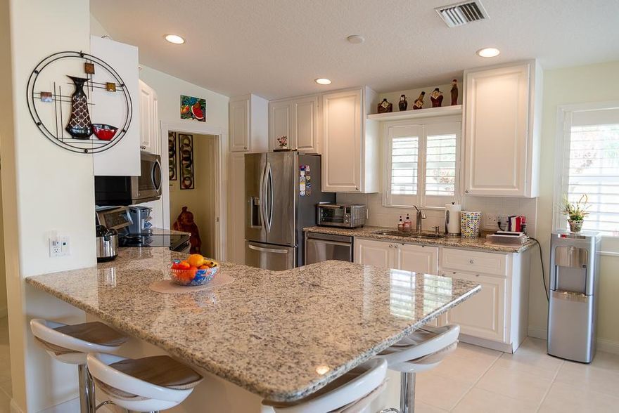 Beautiful villa home with lake view in Tradition! Remodeled gourmet kitchen has open layout with granite counters and new SS appliances, The laundry room features the same gorgeous granite, a new sink and new washer and dryer.  This spacious open floor plan features a storage wall in living area, and new porcelain plank tile in living room and both bedrooms. All windows feature plantation shutters. Other important upgrades include a new AC, water heater, and new garage door opener, and accordion hurricane protection! Enjoy the water views and lush upgraded landscaping from your covered, screened lanai, This stunning home is located very close to the clubhouse, gym, and swimming pools! HOA fees include cable, internet, security alarm system/monitoring, all lawn maintenance, and HOA fees include cable, internet, security alarm system/monitoring, all lawn maintenance, and exterior painting. Community amenities include: 24 hour manned gate, 2 heated pools, tennis, basketball, gym, bocce, pickleball,  clubhouse, game/card room, playground. Easy walk or bike ride to shopping and dining in downtown Tradition.
Chandelier in dining area does not convey.