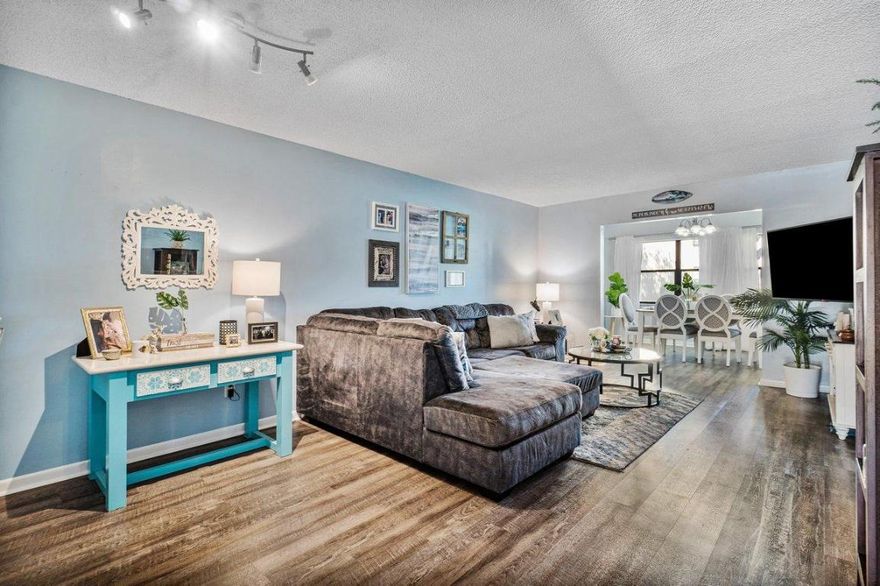 ALL AGES WELCOME in this golf course community (no golf fee required)!!!! Beautifully upgraded first floor home featuring 2 bedrooms and 2 bathrooms, stainless steel appliances, wood cabinets, vanities and light fixtures. Master bedroom boasts large walk-in-closet. Luxury waterproof vinyl plank flooring throughout. A/C 2 years new! Security system.  Spend your evenings on the covered screened patio enjoying the lush grounds and quiet surroundings. This listing won't last long!  Washer and Dryer convey ONLY with full price executed contract.