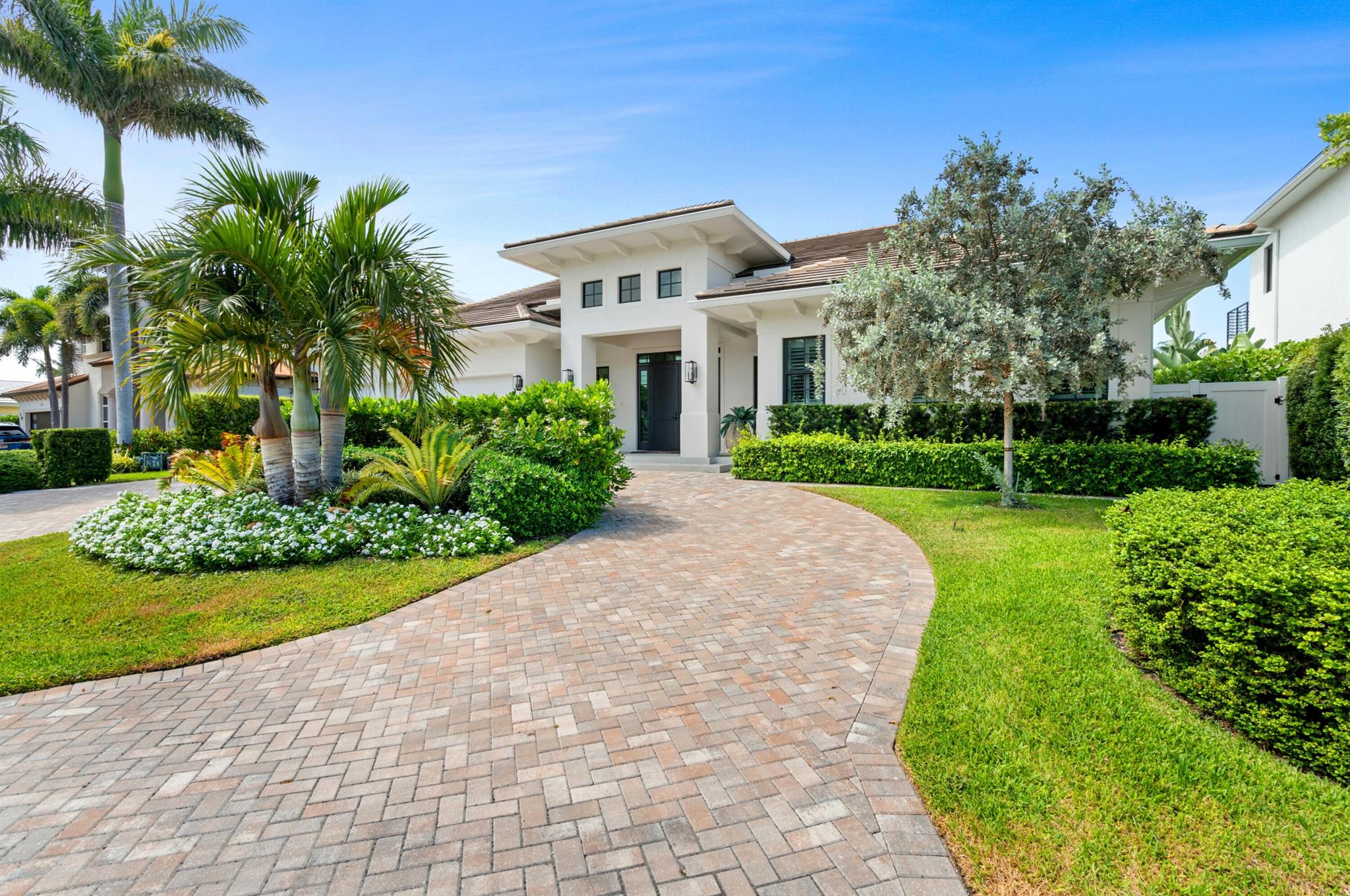 Chic 2022-built estate in desirable Tropic Isle, Delray Beach, offers 90 feet on a canal with a dock off the Intracoastal. Interior details include a chic living room with a linear gas fireplace and full bar, a stunning glass-encased wine display, gourmet cook-island kitchen with Thermador appliances, a luxurious pool-view primary suite, two offices and a poolside loggia and summer kitchen.