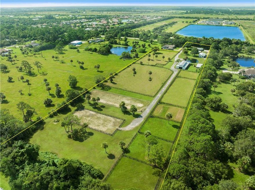 8.63-acre equestrian property in Vero Beach featuring a pond, mature oaks, fully fenced grounds, three barns with over 9,000 sq ft of covered space, 16 stalls, 2 feed and tack rooms, and bathroom facilities, a dressage arena, schooling arena, and multiple turn-out paddocks. The 3-bedroom, 2-bath CBS ranch home offers a split layout with walk-in closets, open kitchen with stainless appliances, and vinyl flooring throughout. The house has a large extra space that can be converted into a mother in law or helper's apartment. Paver patio and open porch. The 30x15 heated pool rounds out the outdoor space. Newer roof, AC, and water heater. County water and paved road access.