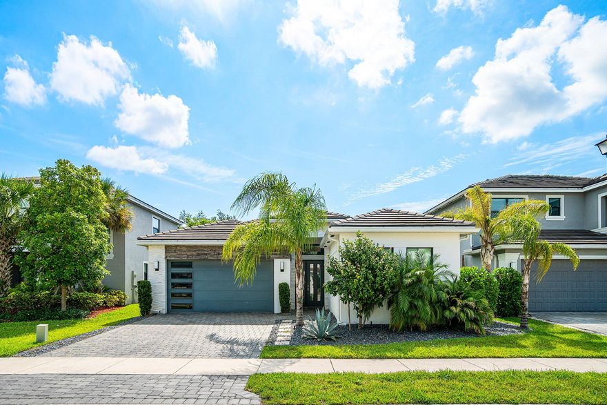 Experience refined South Florida living in this exceptional 2022-built residence designed with style, comfort, and convenience in mind. This beautifully appointed 3-bedroom plus den home features a bright open layout with high-end finishes and modern design throughout. From the moment you enter, you'll notice the attention to detail, including sleek porcelain flooring, custom feature walls, upgraded lighting, and sophisticated designer touches in every space.  The gourmet kitchen blends functionality with contemporary elegance, while the luxurious bathrooms offer a spa-like feel with premium upgrades and striking finishes. Built with today's lifestyle in mind, the home includes impact glass, smart-home integration, natural gas, a tankless water heater,  and a full-house generator for ultimate efficiency and peace of mind.  Step outside into a completely private backyard retreat featuring a stunning gas-heated pool and spa, lush low-maintenance turf, and fenced outdoor living space perfect for entertaining or relaxing year-round. This is turnkey luxury living at its finest with absolutely nothing left to do but move in and enjoy.